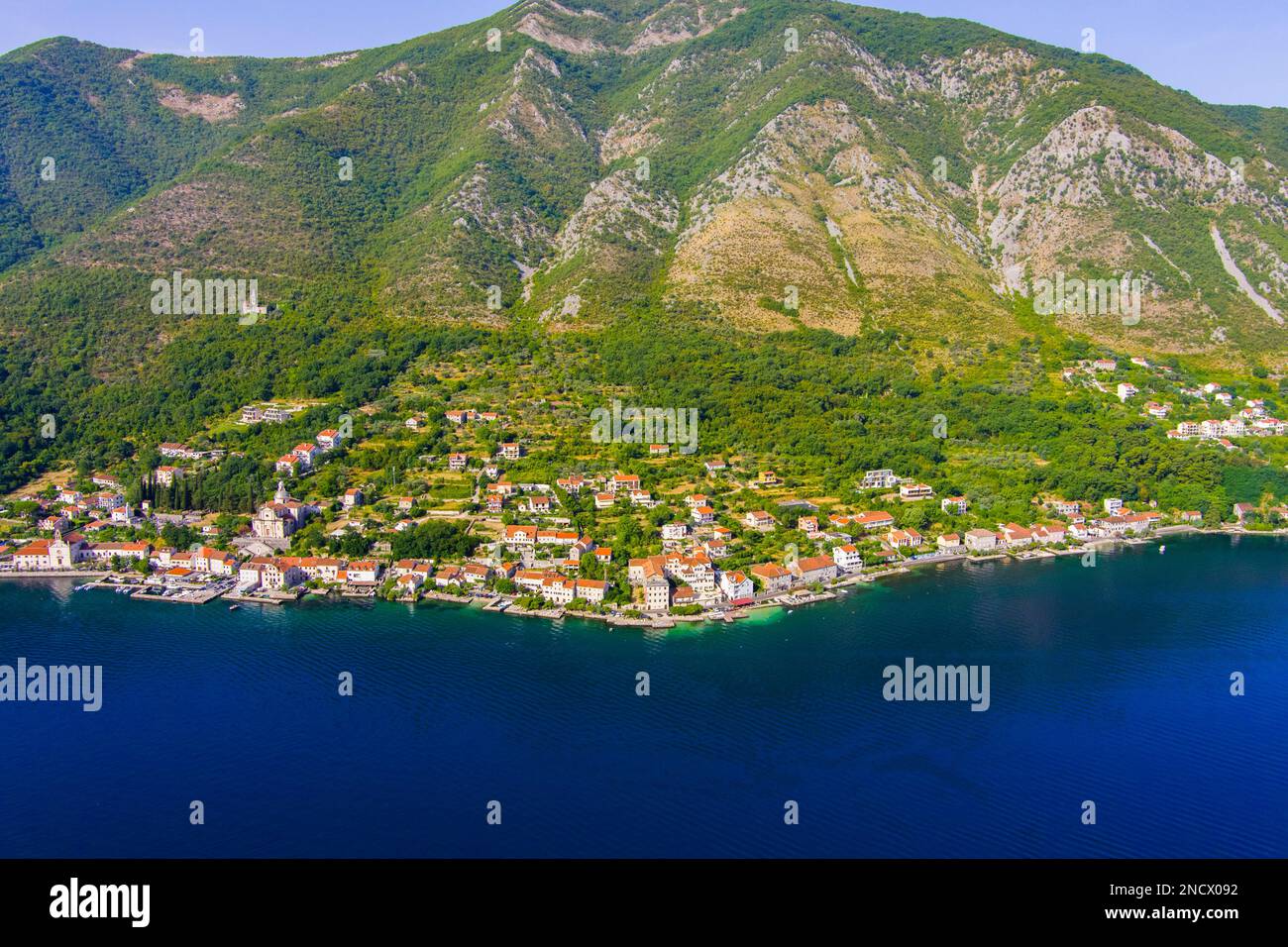 Monténégro. Mer Adriatique. Baie de Kotor. Site touristique populaire. Village sur la côte. Maisons avec toits de tuiles orange. Saison touristique. Drone. Vue aérienne Banque D'Images