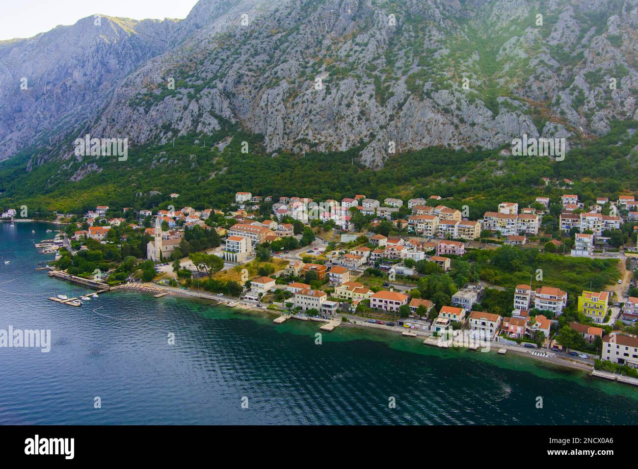 Monténégro. Mer Adriatique. Baie de Kotor. Site touristique populaire. Village sur la côte. Maisons avec toits de tuiles orange. Saison touristique. Drone. Vue aérienne Banque D'Images