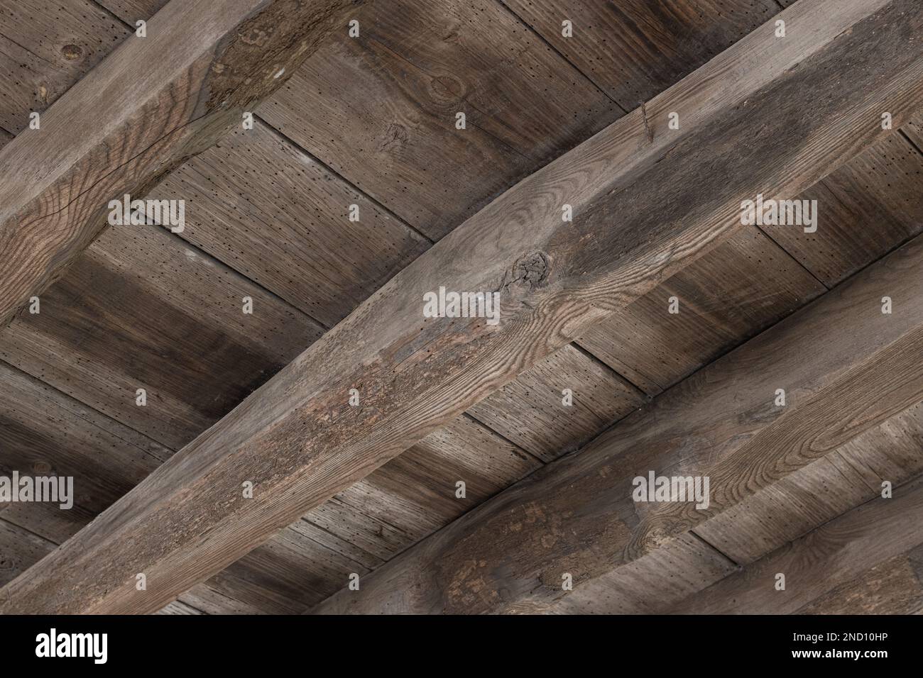 Vue du dessous d'une ancienne structure de plancher en bois d'un bâtiment endommagé par des trous de ver à bois Banque D'Images Vue du dessous d'une ancienne structure de plancher en bois d'un bâtiment endommagé par des trous de ver à bois Banque D'Images