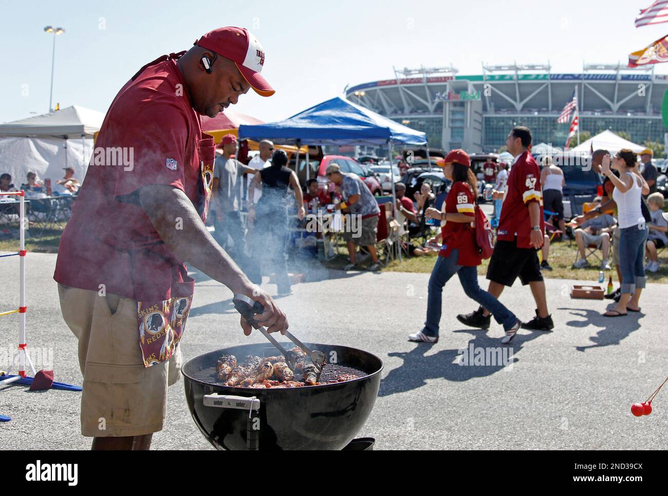 Warren Sumlin barbecues in the parking lot of FedEx Field before an NFL  football game between the Washington Redskins and Houston Texans in  Landover, Md., on Sunday, Sept. 19, 2010. (AP Photo/Evan