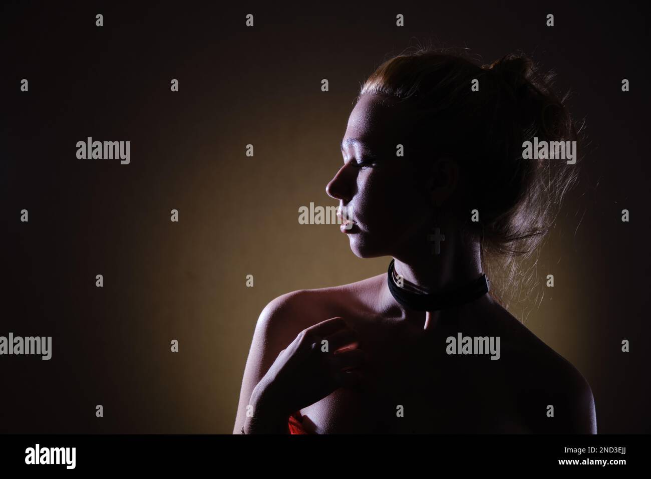 Portrait de beauté d'une femme triste en robe noire aux épaules nues, cheveux blond regardant de côté profil vue monochrome Banque D'Images