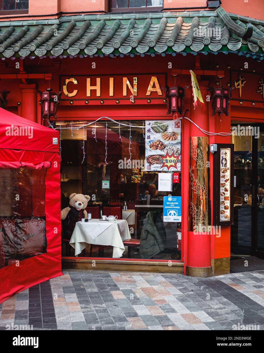 Un panda semble regarder par la fenêtre d'un restaurant chinois dans le quartier chinois de Londres. Banque D'Images
