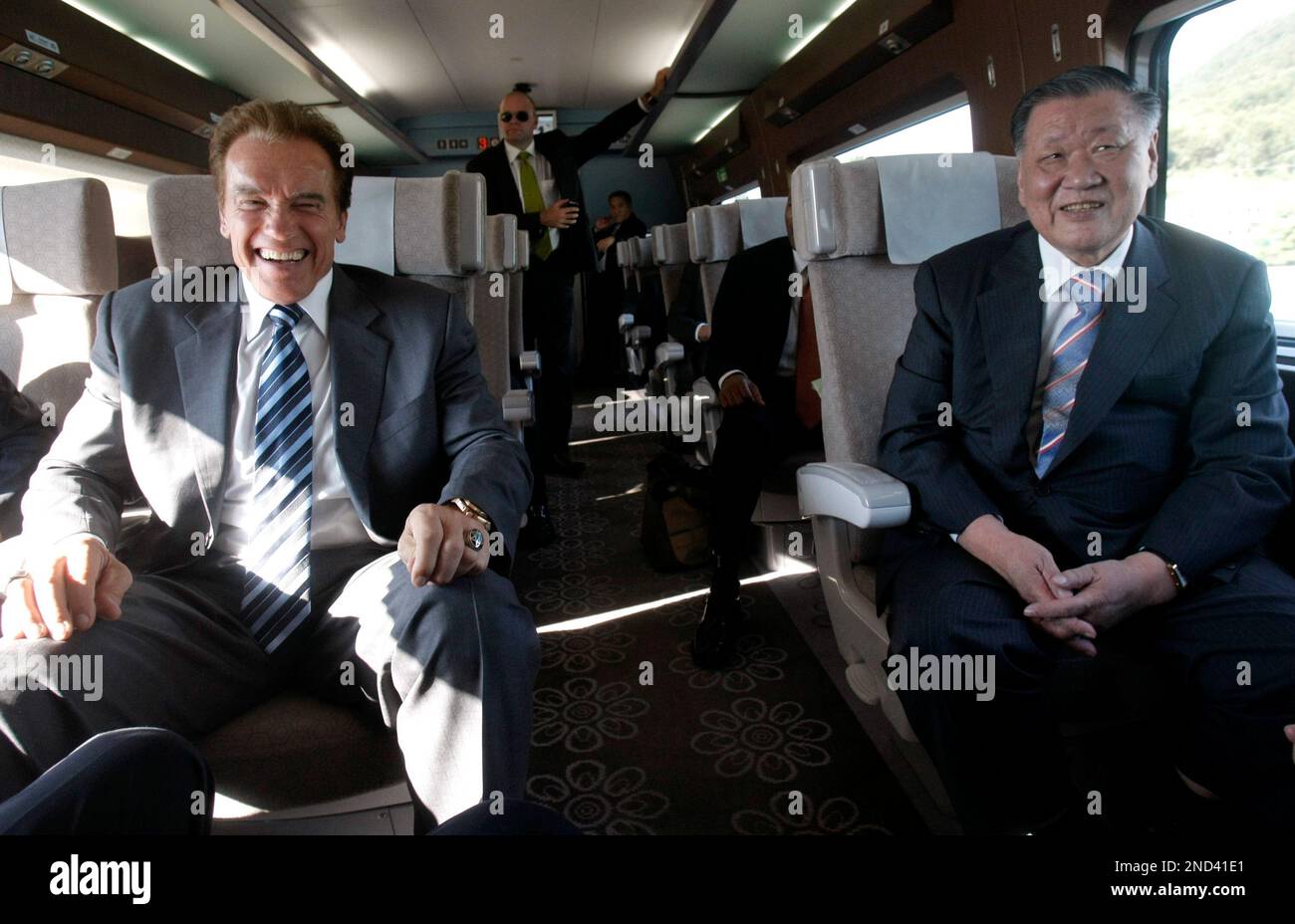 California Gov. Arnold Schwarzenegger, left, and Chung Mong-koo, chairman of Hyundai-Kia Automotive Group, smile while taking a ride on the South Korean-made high-speed KTX train in Seoul, South Korea, Wednesday, Sept. 15, 2010. California, the biggest U.S. state in population, has proposed a high-speed rail network and Schwarzenegger is using the Asian trip to sample fast train technologies in the three countries. (AP Photo/Ahn Young-joon) Banque D'Images