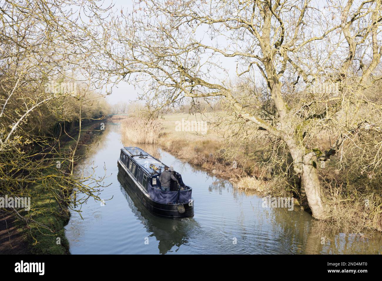 Northamptonshire, Angleterre : un couple profite du soleil de la fin de l'hiver lorsqu'il navigue sur un bateau à rames le long du Grand Union Canal près de Crick. Banque D'Images