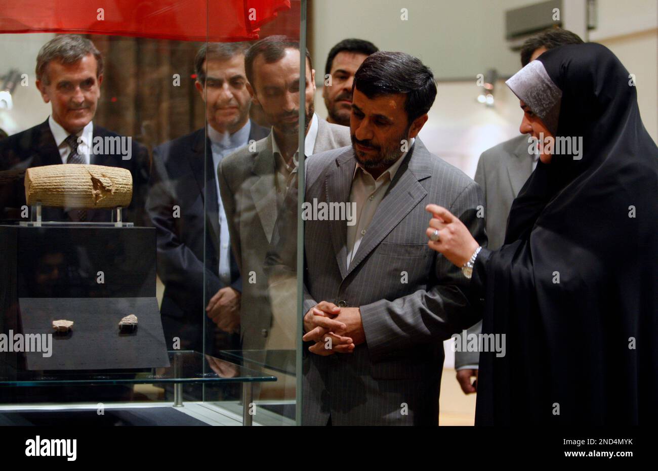 Head of the National Museum of Iran, Azadeh Ardakani, right, briefs Iranian President Mahmoud Ahmadinejad, second right, as he visits the Cyrus Cylinder, at the museum, in Tehran, Iran, Sunday, Sept. 12, 2010. A Babylonian artifact sometimes described as the world's first human rights charter is to go on display in Iran after the government threatened to cut ties with the British Museum if it did not loan the object. The Cyrus Cylinder is a sixth century B.C. clay object inscribed with an account in cuneiform of the conquest of Babylon by the Persian King Cyrus the Great. It arrived in Iran on Banque D'Images