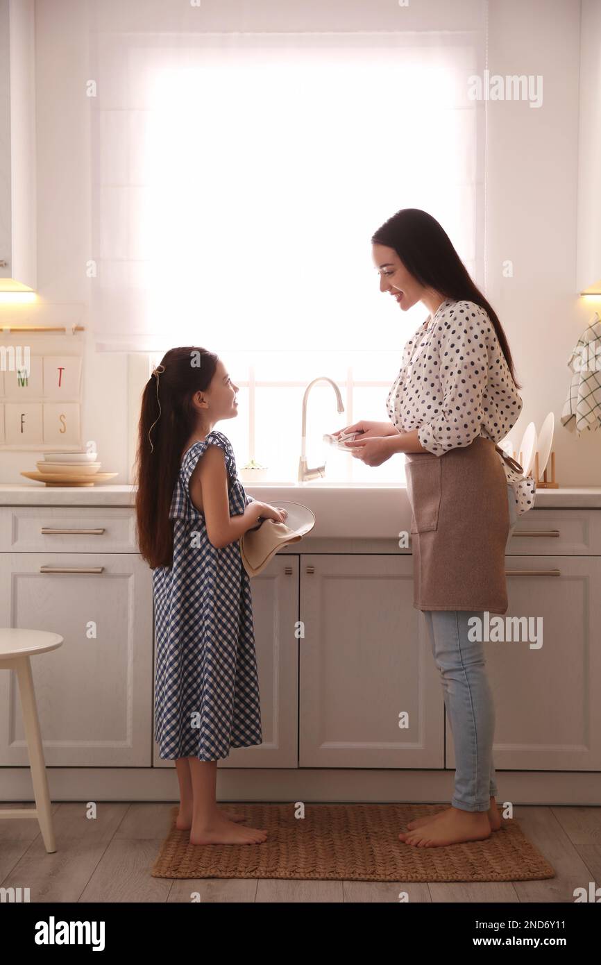 La mère et la fille essuyent les plats ensemble dans la cuisine Banque D'Images
