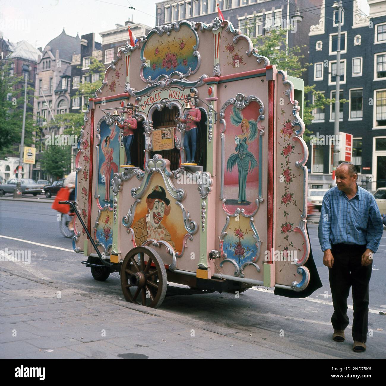 Fin 1960s, historique, homme debout par un orgue traditionnel, dans une rue d'Amsterdam, Hollande, pays-Bas. L'instrument de musique provient du célèbre constructeur d'orgue Gijs Perlee de Westerstraat, Amsterdam, la plus ancienne des familles hollandaises d'orgue à canon. Banque D'Images