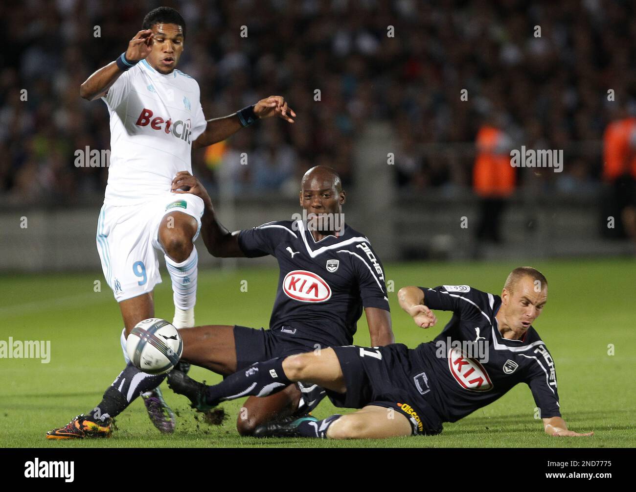 Marseille's Brandao, left, is tackled by Bordeaux's Mathieu Chalme, right,  and Michael Ciani, center, during their French League one soccer match in  Bordeaux, southwestern France, Sunday, Aug. 29, 2010. (AP Photo/Bob Edme