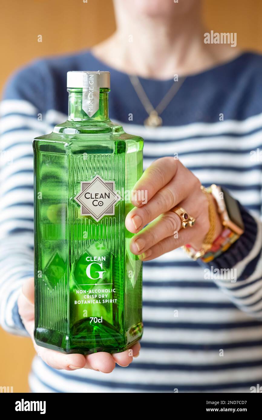 Une femme détient une bouteille de 70cl de CleanCo Clean G. Une