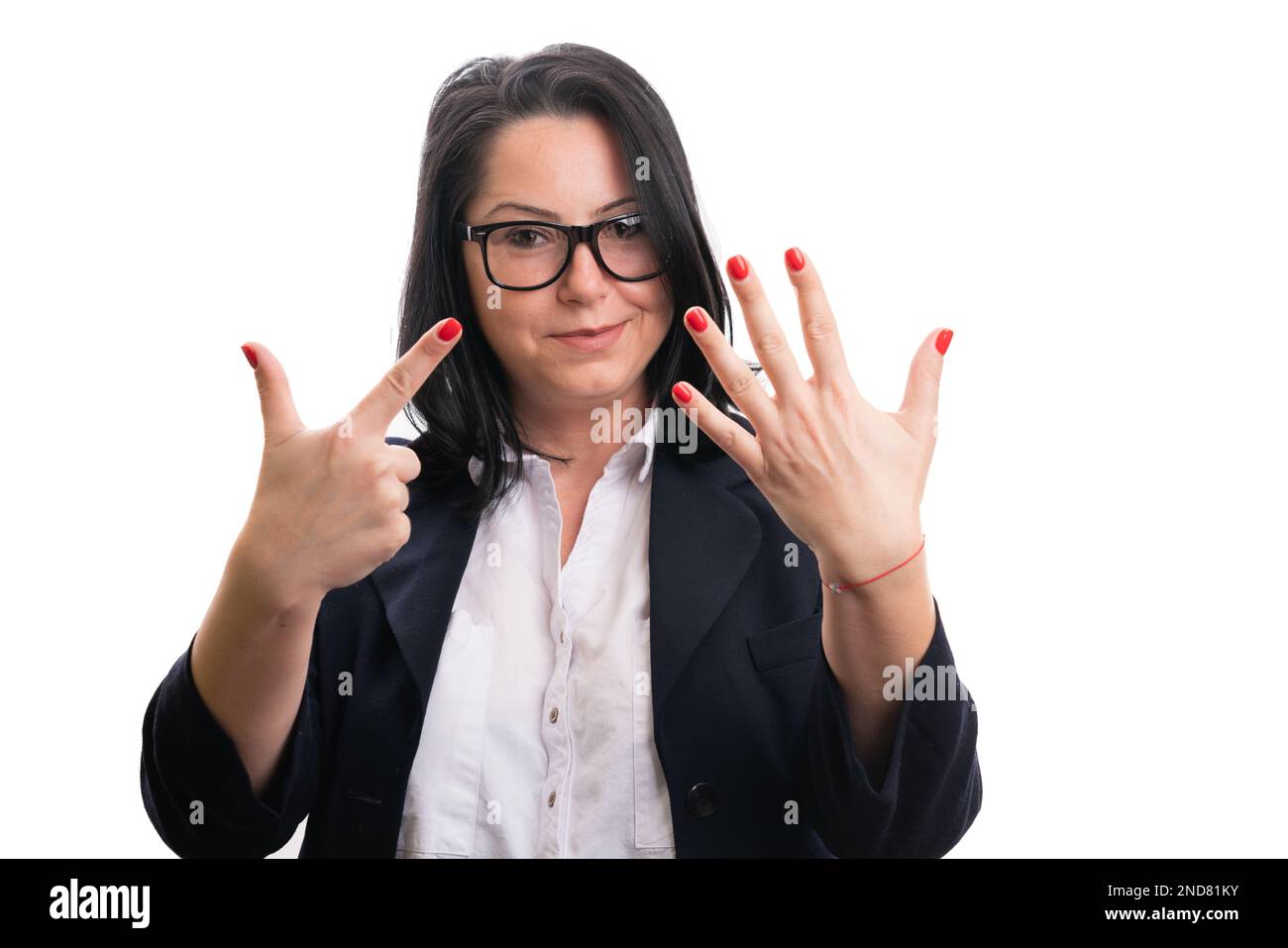 Sympathique femme entrepreneur souriant comme montrant le numéro sept comptant en utilisant les doigts portant la combinaison décontractée isolée sur fond blanc studio Banque D'Images