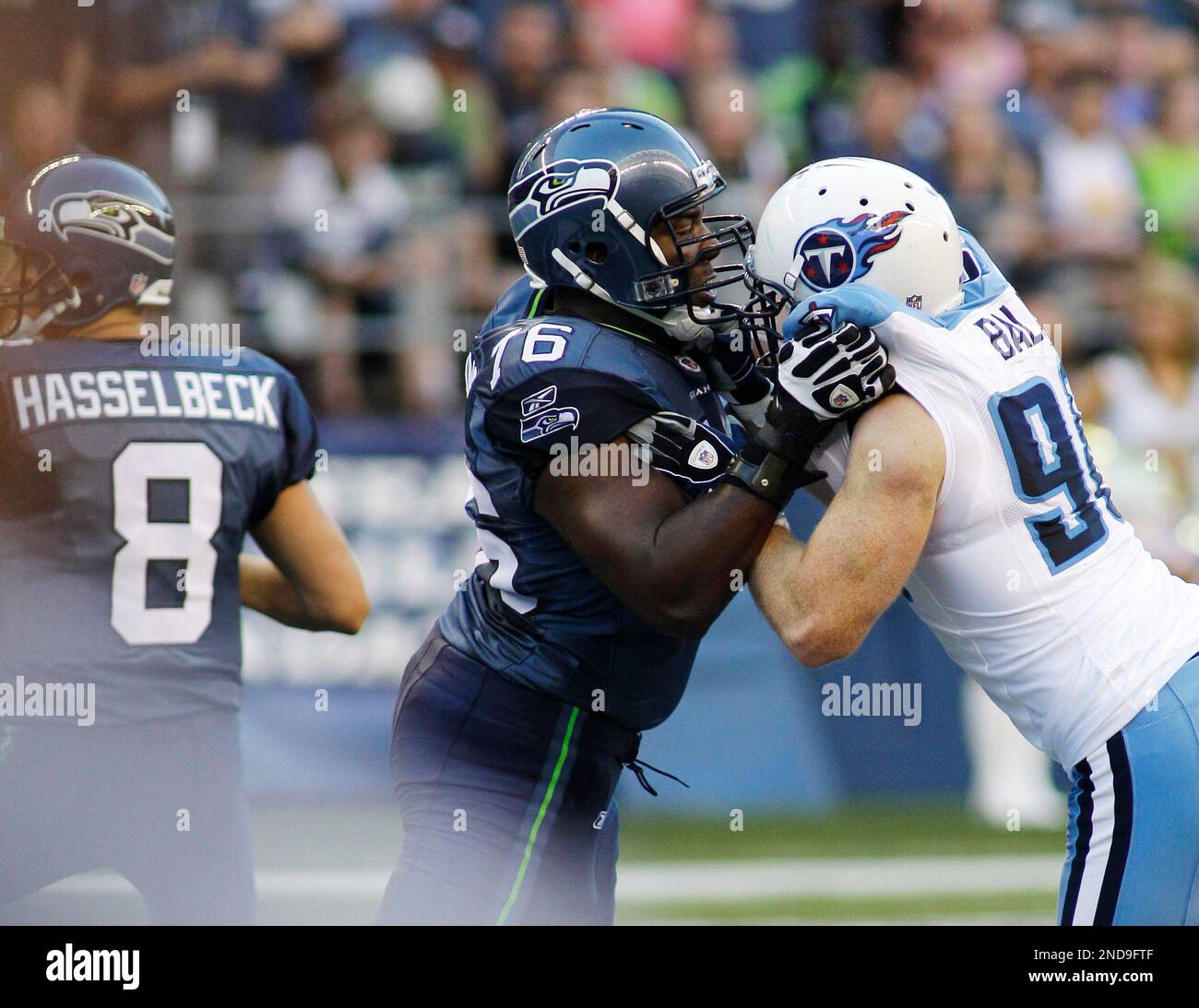 Seattle Seahawks' Russell Okung , center, tries to keep Tennessee Titans' David Ball, right, away from Seahawks quarterback Matt Hasselbeck, left, in the first half of an NFL preseason football game, Saturday, Aug. 14, 2010, in Seattle. (AP Photo/Ted S. Warren) Banque D'Images