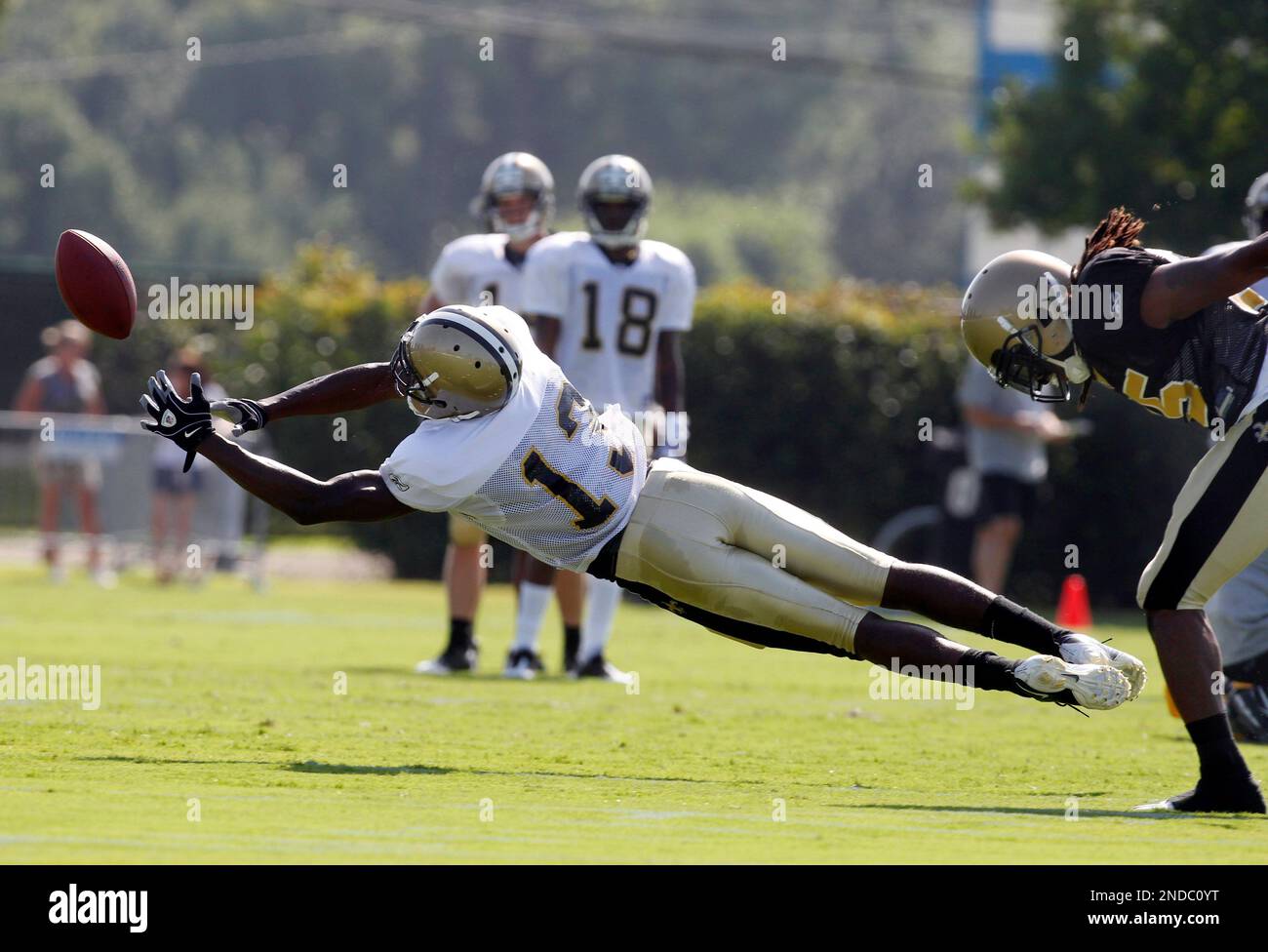 New Orleans Saints wide receiver Rod Harper (13) dives for a pass against cornerback Reggie Jones, right, on the first day of training camp at their NFL football training facility in Metairie, La., Friday, July 30, 2010. (AP Photo/Gerald Herbert) Banque D'Images