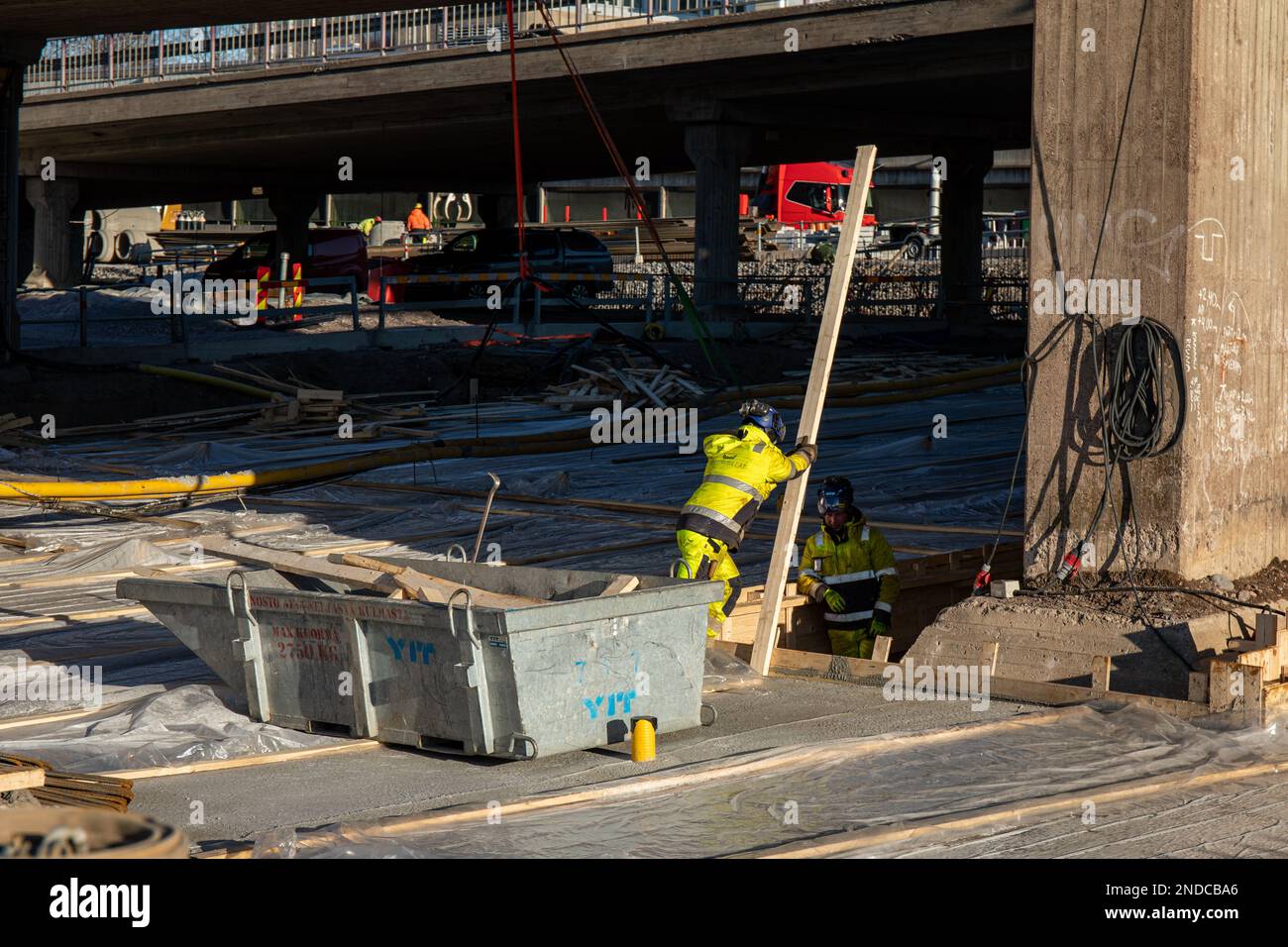 Les hommes au travail. Chantier de construction du pont Hakaniemen silta ou Hakaniemi avec l'ancien pont toujours debout Helsinki, Finlande. Banque D'Images