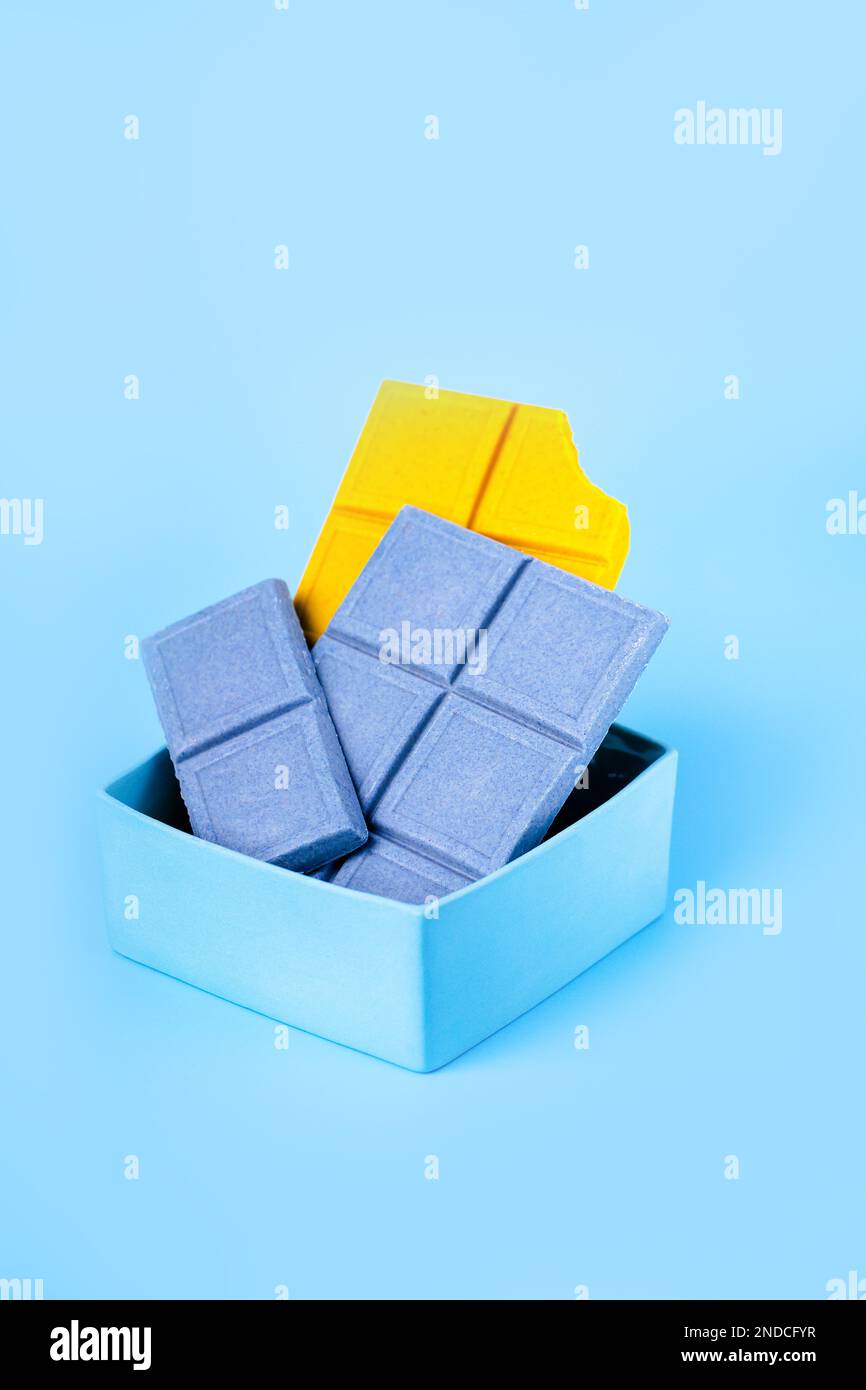 Chocolat jaune citron-gingembre et chocolat bleu avec spiruline sur fond bleu Banque D'Images
