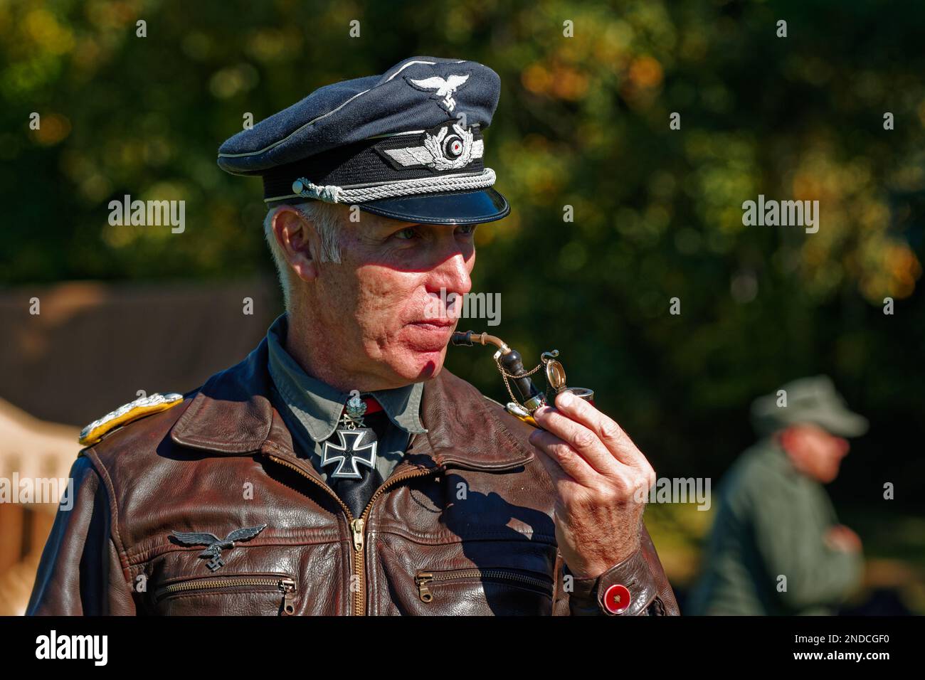 Un officier allemand en veste de cuir fumant un tuyau sur le champ de bataille lors d'une reconstitution au Musée du patrimoine américain. Hudson, Massachusetts Banque D'Images