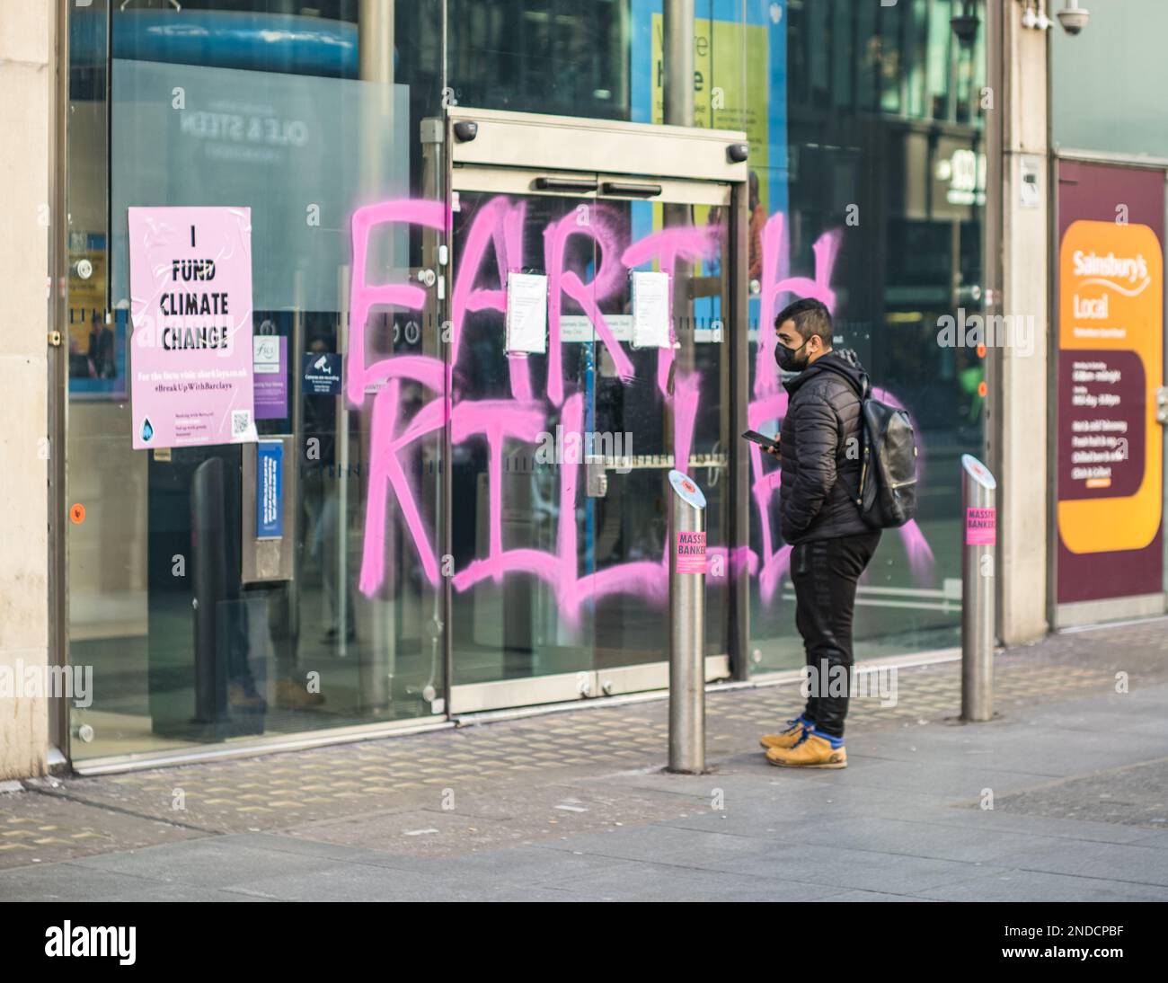 Les militants pour le changement climatique peignent des graffitis « Earth Killer » sur Barclays Bank, succursale de Tottenham court Road, Londres, février 2023. Rébellion de l'extinction. Banque D'Images