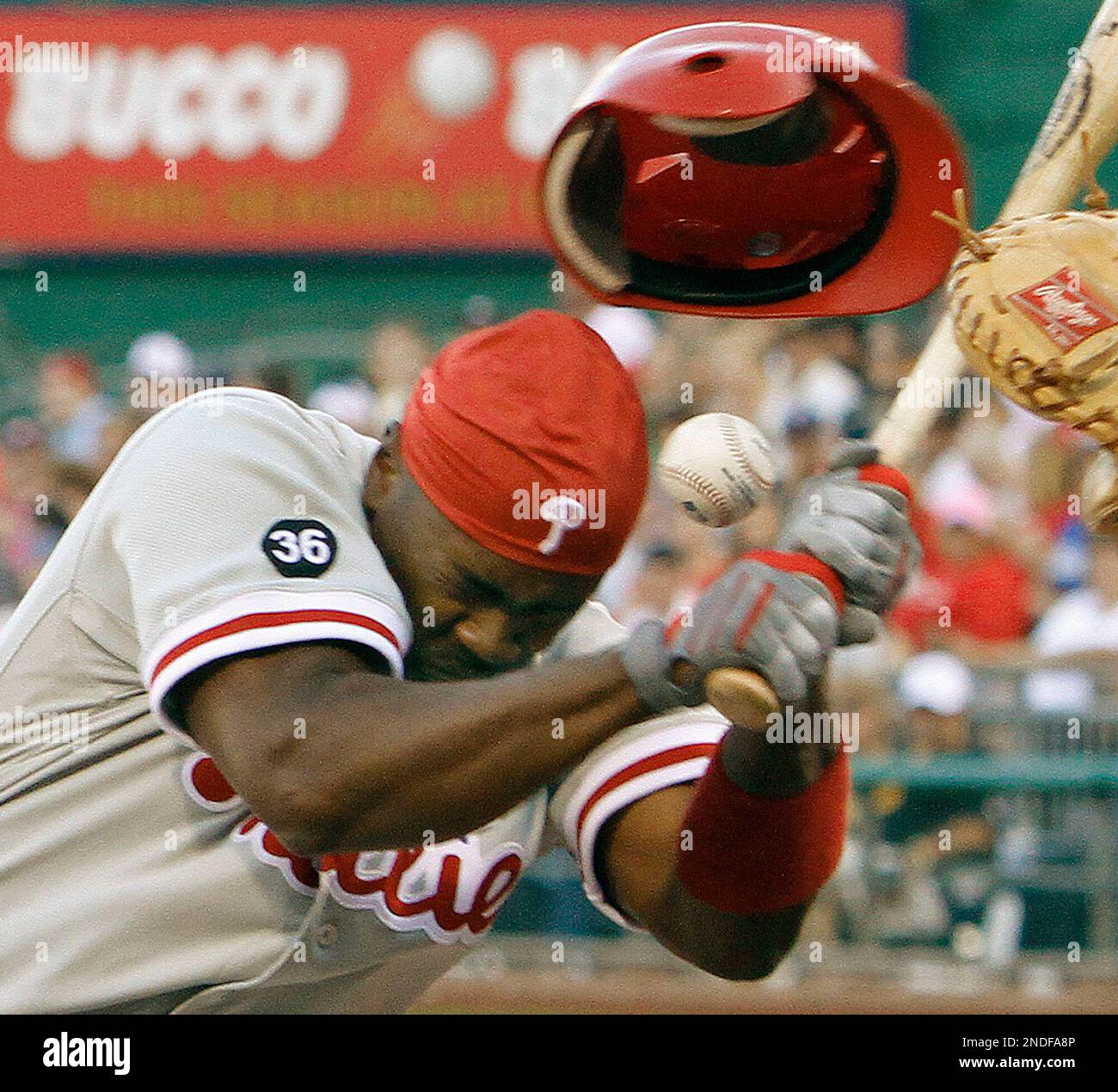 Philadelphia Phillies Jimmy Rollins, left loses his helmet after being hit by a pitch as Pittsburgh Pirates catcher Ryan Doumit reaches for the pitch by Ross Ohlendorf in the third inning of the baseball game in Pittsburgh, Friday, July 2, 2010. (AP Photo/Keith Srakocic) Banque D'Images