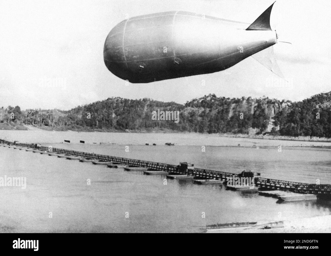 The first barrage balloons to fly over Burma, are those of No. 2, mobile balloon flight, which are being used to guard the Bailey bridge over the Chindwin River near Kalewa, the longest pontoon Bailey bridge over built in any theatre of war. Officer Commanding the Balloon flight is Flight Lieutenant J.D. Buck of Bassett Gardens, Southampton. One of the balloons guarding the 360 yards long pontoon Bailey Bridge over the Chindwin Feb. 13, 1945. (AP Photo) Banque D'Images