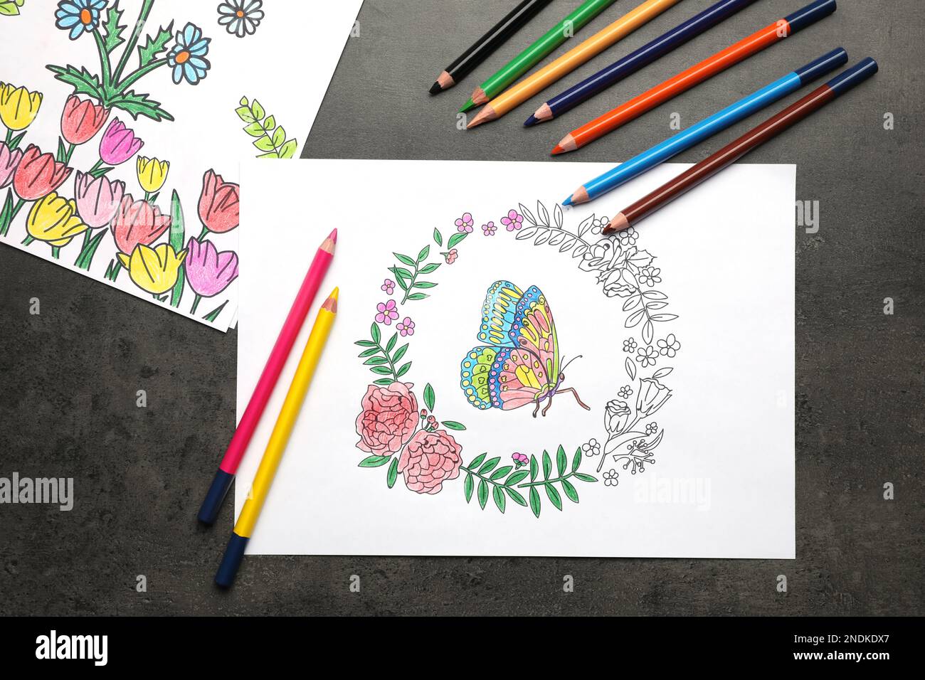 Pages de coloriage avec dessins d'enfants et jeu de crayons sur table grise, plat Banque D'Images