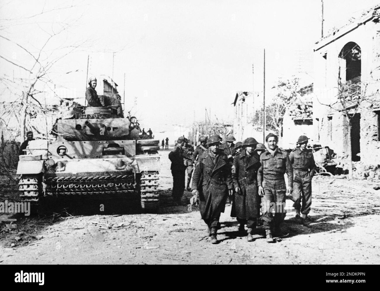 The marching soldiers are British Tommies captured by the Nazis in Tebourba, Tunisia, Jan. 6, 1943. German tanks and tank grenadiers mop up Tebourba after the fall of that town. The Tommies have left their hiding places and are taken prisoners. (AP Photo) Banque D'Images