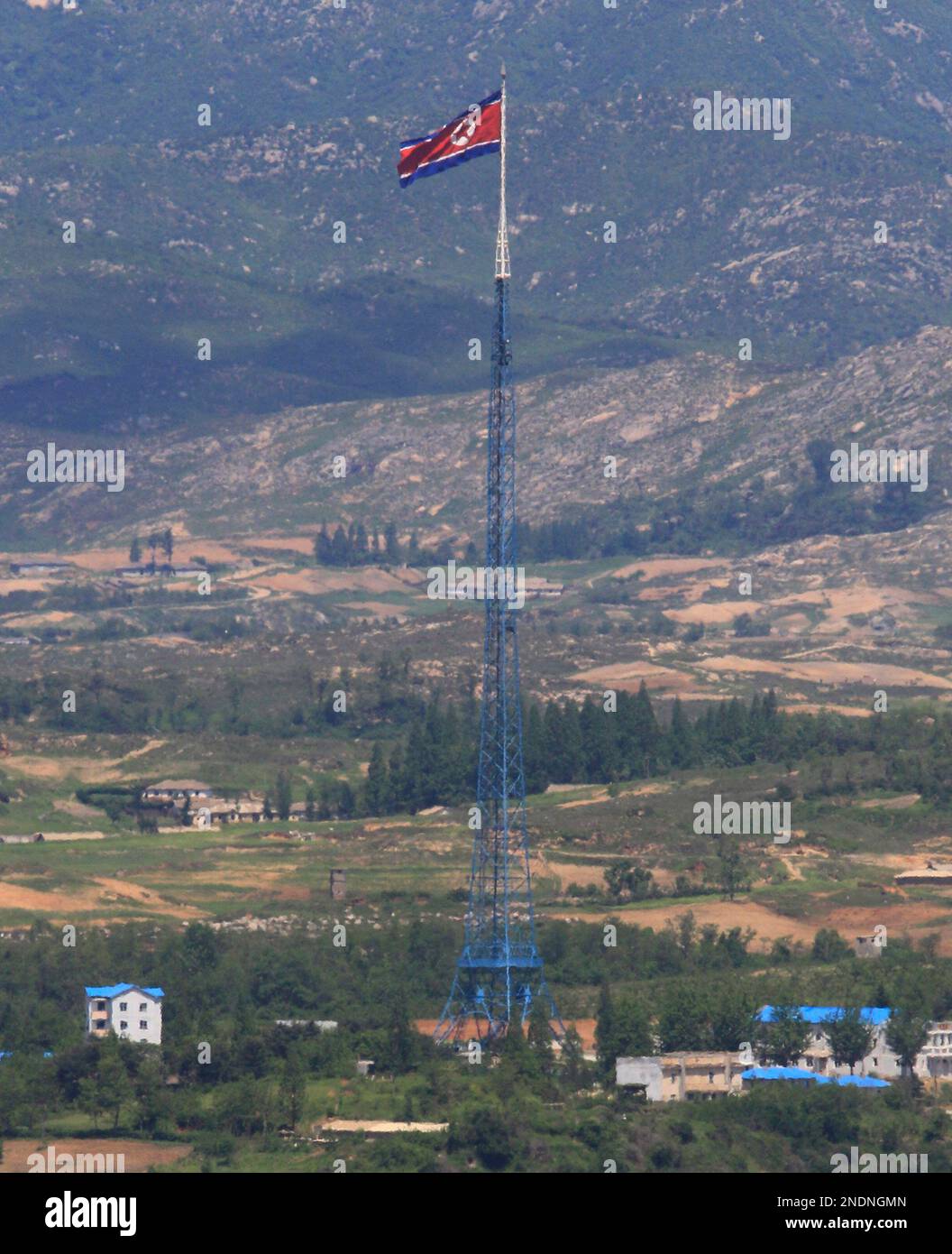 A giant North Korean flag atop a 160-meter (533-foot) tower fly in North Korea as pictured from Dora Observation Post in the demilitarized zone (DMZ) near the border village of Panmunjom that separates the two Koreas since the Korean War, in Paju, north of Seoul, South Korea, Wednesday, May 26, 2010. North Korea has threatened to ban cross-border traffic and destroy South Korean propaganda loudspeakers, a day after it declared it would cut all ties with Seoul for blaming the regime for a deadly warship sinking. (AP Photo/ Lee Jin-man) Banque D'Images