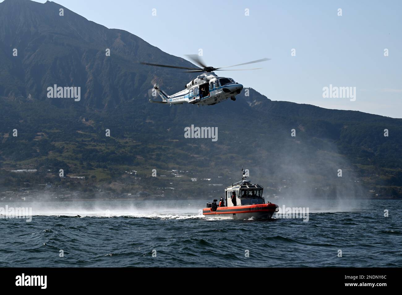 Un équipage d'hélicoptère AgustaWestland AW139 de la Garde côtière japonaise se prépare à lever un technicien de sauvetage mobile de la Garde côtière japonaise des États-Unis Petit bateau intercepteur à longue portée de 35 pieds de Kimball’s (WMSL 756) lors d’un exercice conjoint de recherche et de sauvetage dans la baie Kagoshima (Japon), le 14 février 2023. L’équipage de Kimball est à Kagoshima pour mener une formation conjointe et des échanges professionnels avec les membres de la Garde côtière japonaise, en développant un protocole de coopération signé en 2022 entre les deux services maritimes, qui a établi l’opération SAPPHIRE, une opération perpétuelle visant à renforcer les relations, Banque D'Images