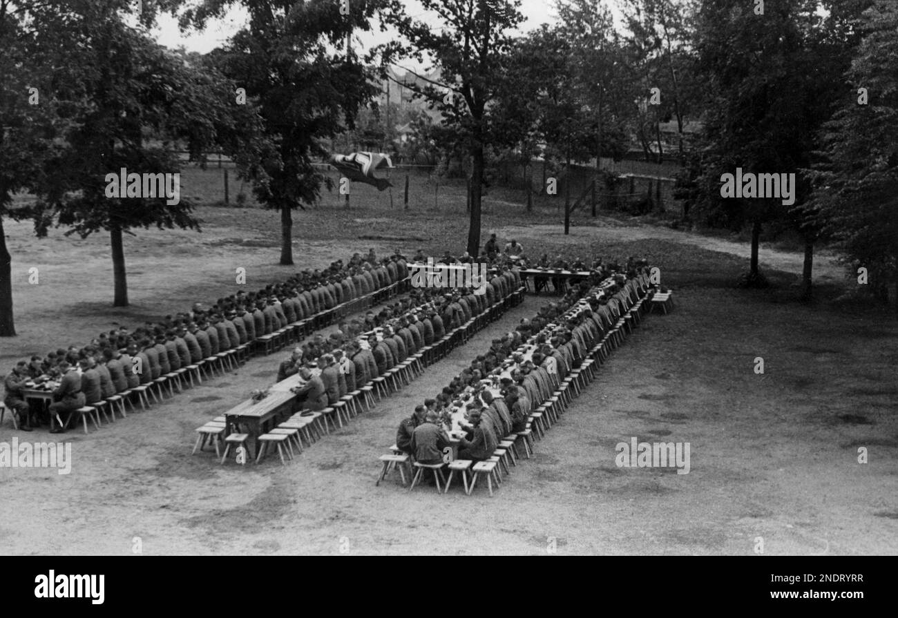 Soldats du Régiment 10th SS Totenkopf pendant un repas en plein air avec le gouverneur Hans Frank. Banque D'Images