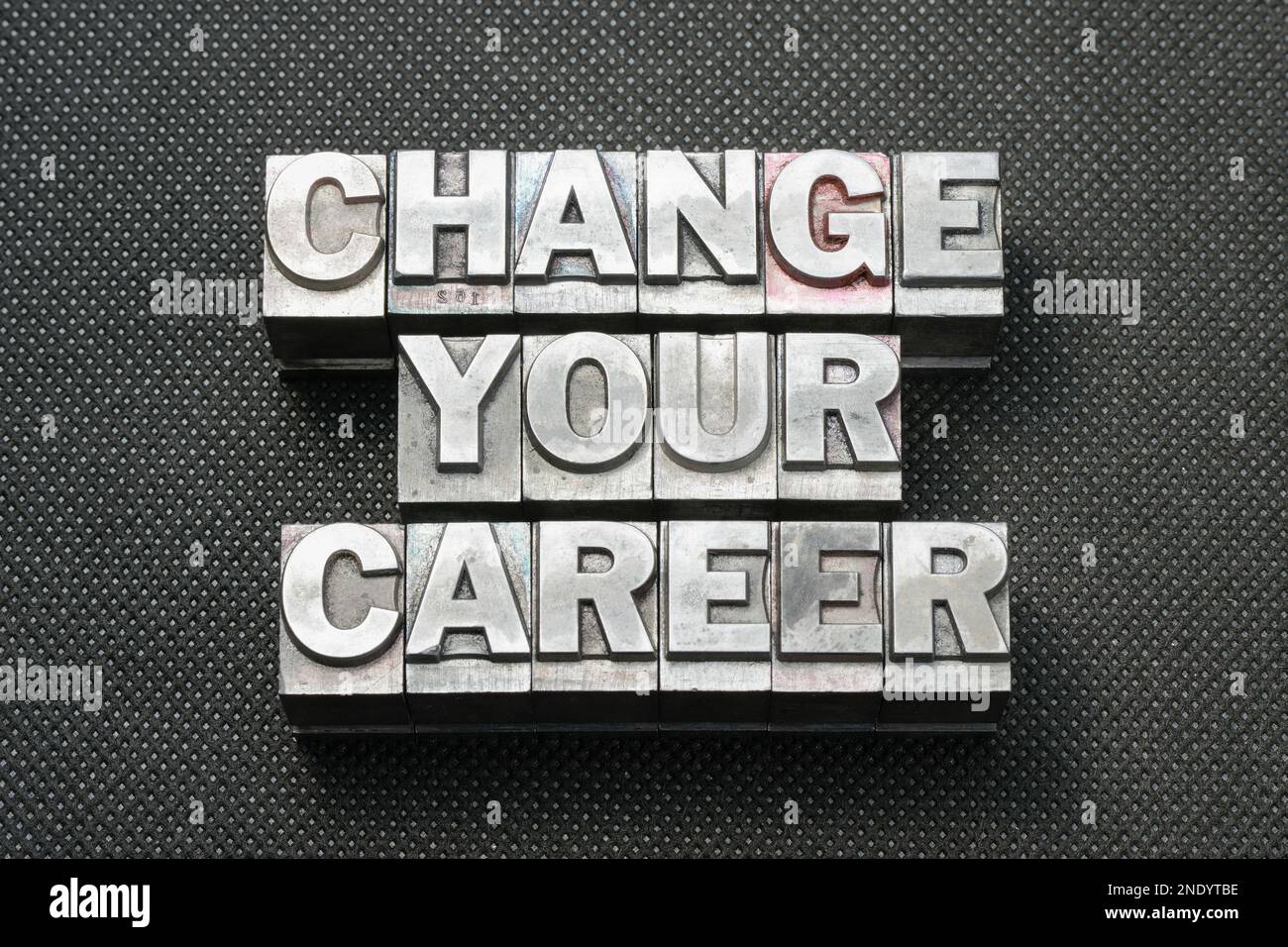 changez votre phrase de carrière faite de blocs de typographie métalliques sur la surface noire perforée Banque D'Images