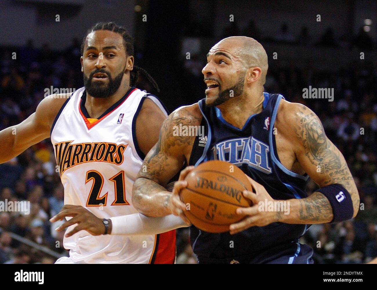 Utah Jazz's Carlos Boozer, right, drives against Golden State Warriors' Ronny Turiaf during the first half of an NBA basketball game Tuesday, April 13, 2010, in Oakland, Calif. (AP Photo/Ben Margot) Banque D'Images