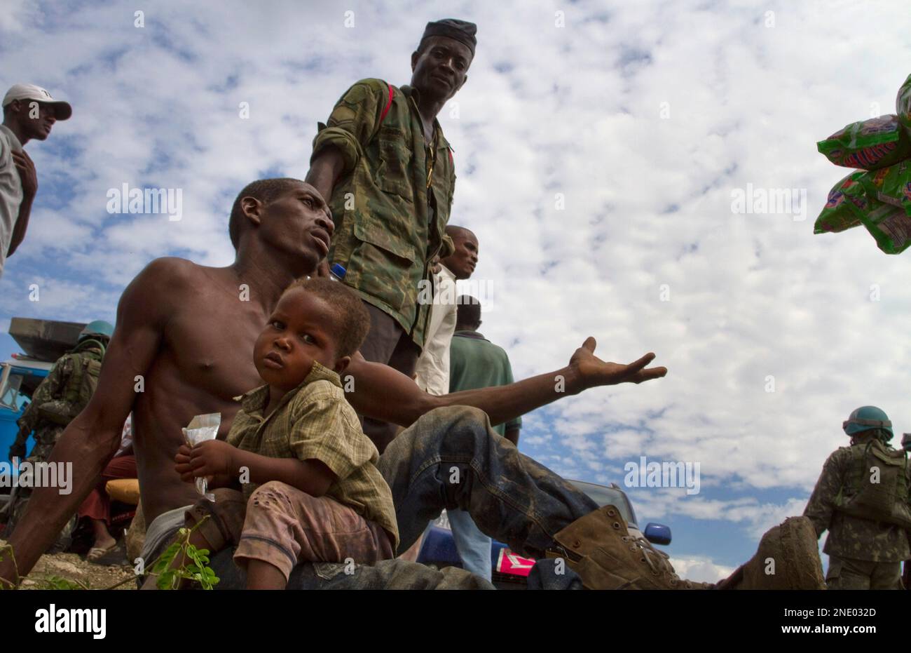 A man with his son asks for help during a food distribution at a homeless earthquake survivors' camp in Port-au-Prince, Monday, April 12, 2010. The 7.0-magnitude earthquake that hit Haiti on Jan. 12 left over a million people living in makeshift camps. (AP Photo/Ramon Espinosa) Banque D'Images