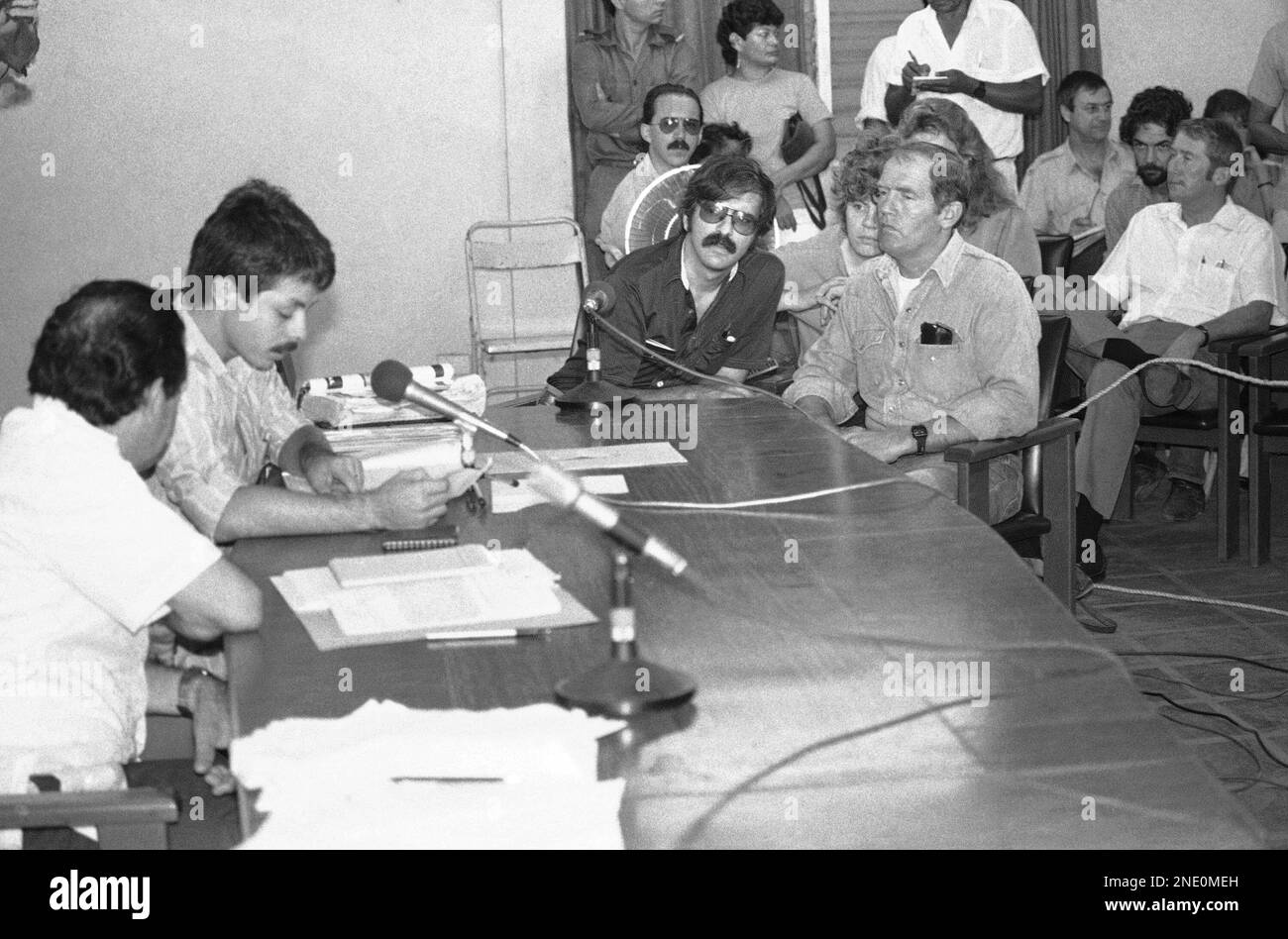 American Eugene Hasenfus, right, listens through an interpreter, second from right, as a Nicaraguan pilot reads from the log book found in the wreckage of the plane shot down with Hasenfus aboard, Hasenfus is on trial for his role in flying supplies to rebel ?contra? forces, Nov. 3, 1986. (AP Photo/Garcia) Banque D'Images