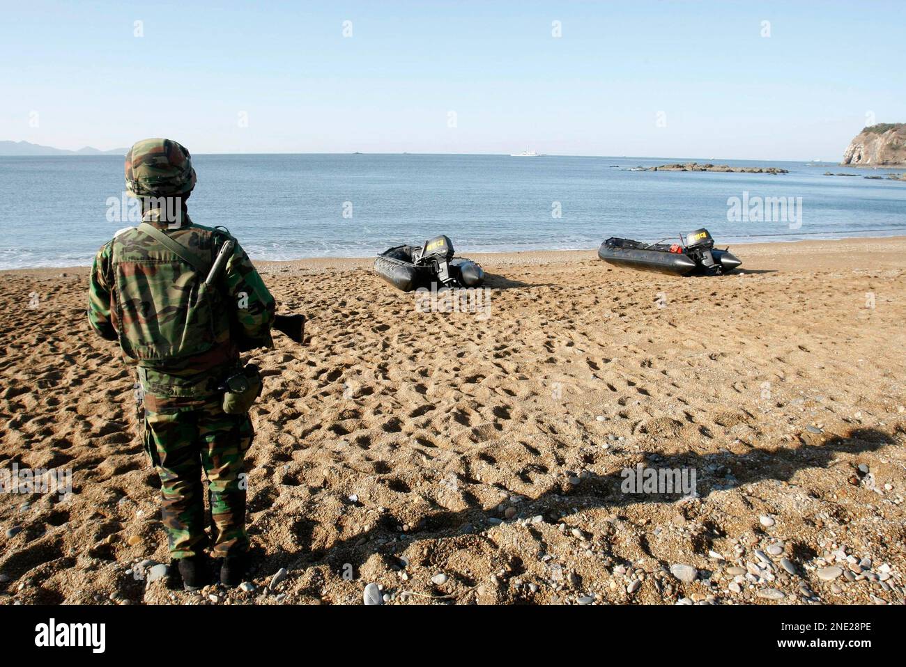 A South Korean Marine stands guard during search for survivors from a sunken South Korean naval ship on South Korea's Baengnyeong Island, on Sunday, March 28, 2010. The 1,200-ton Cheonan, exploded and sank near the tense maritime border with North Korea late Friday. (AP Photo/Ahn Young-joon) Banque D'Images