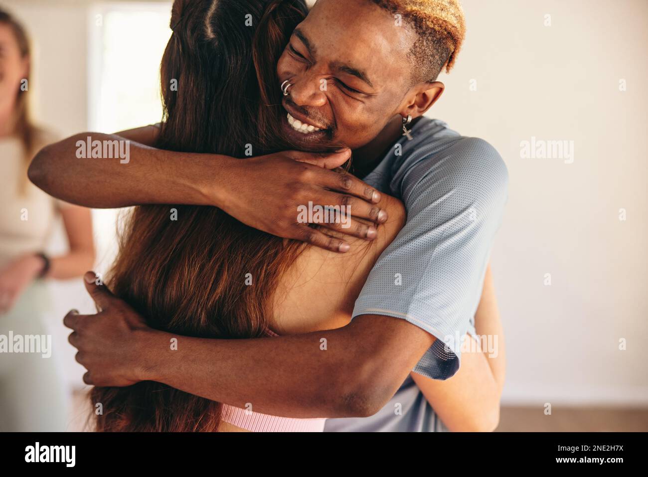 Jeune homme embrassant son ami de fitness dans un studio de yoga. Deux jeunes disent Au revoir après une séance de yoga dans un studio de fitness communautaire. Banque D'Images