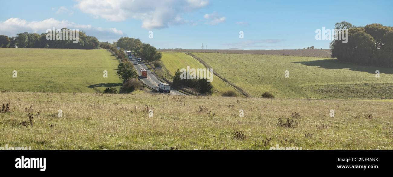 autoroute lourde utilisée traversant les terres agricoles d'été, champs de campagne, paysage, notion de pollution de la circulation Banque D'Images