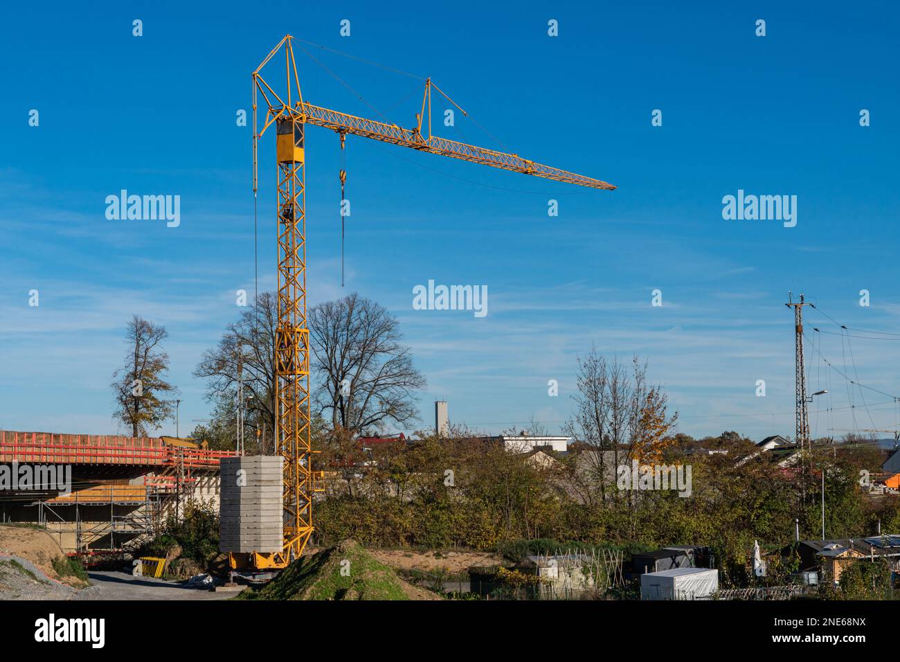 Chantier de construction avec une grande grue de construction jaune. Ciel bleu avec nuages clairs. Banque D'Images