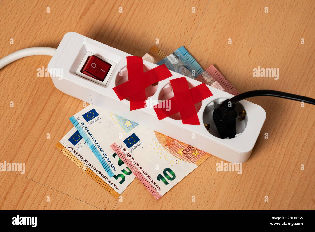 La rallonge électrique à trois prises se trouve sur les billets de banque. Deux prises femelles scellées avec du ruban électrique rouge. Crise énergétique mondiale. Banque D'Images