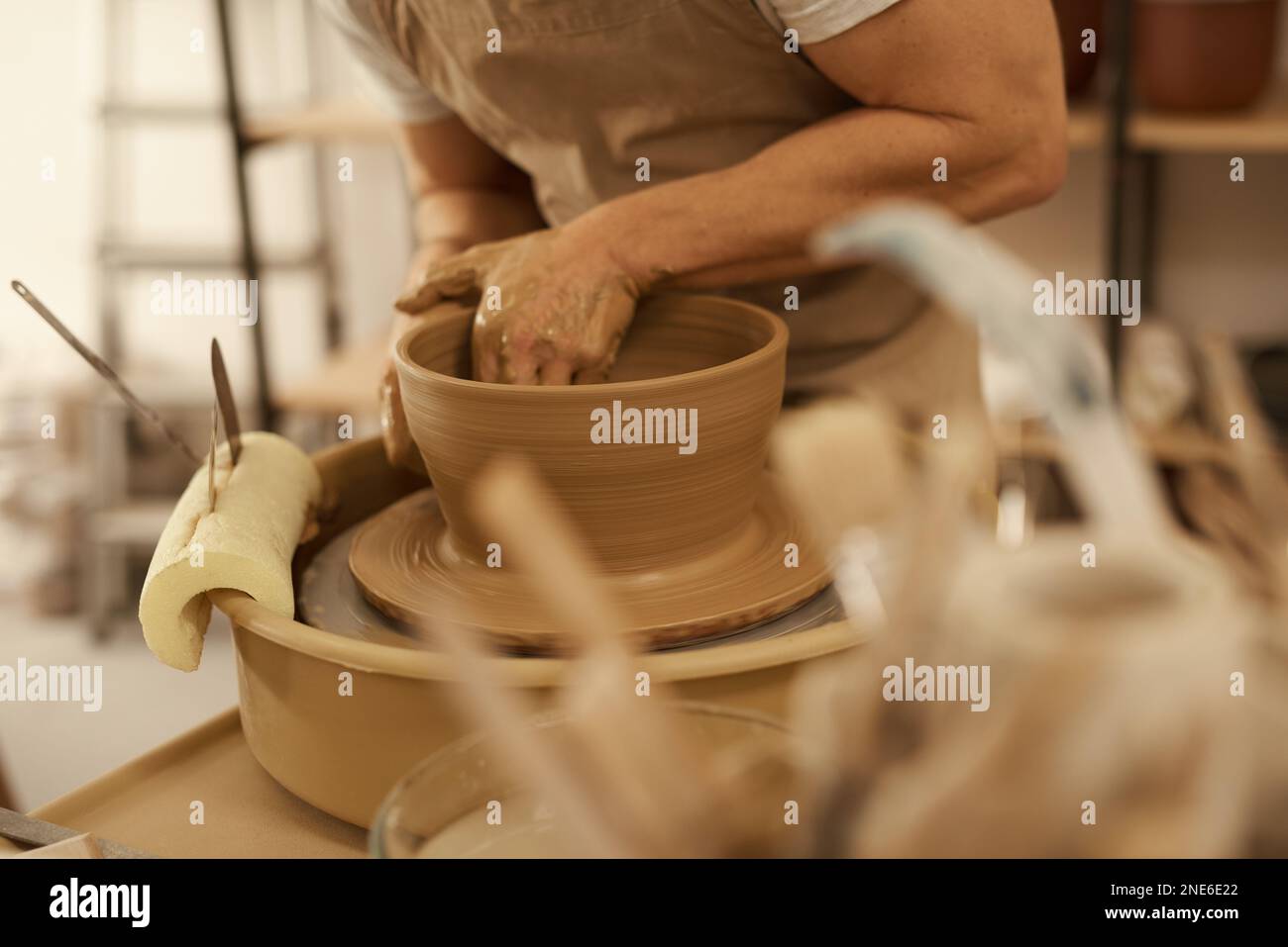 Potier tournant un bol sur une roue dans un studio de céramique Banque D'Images