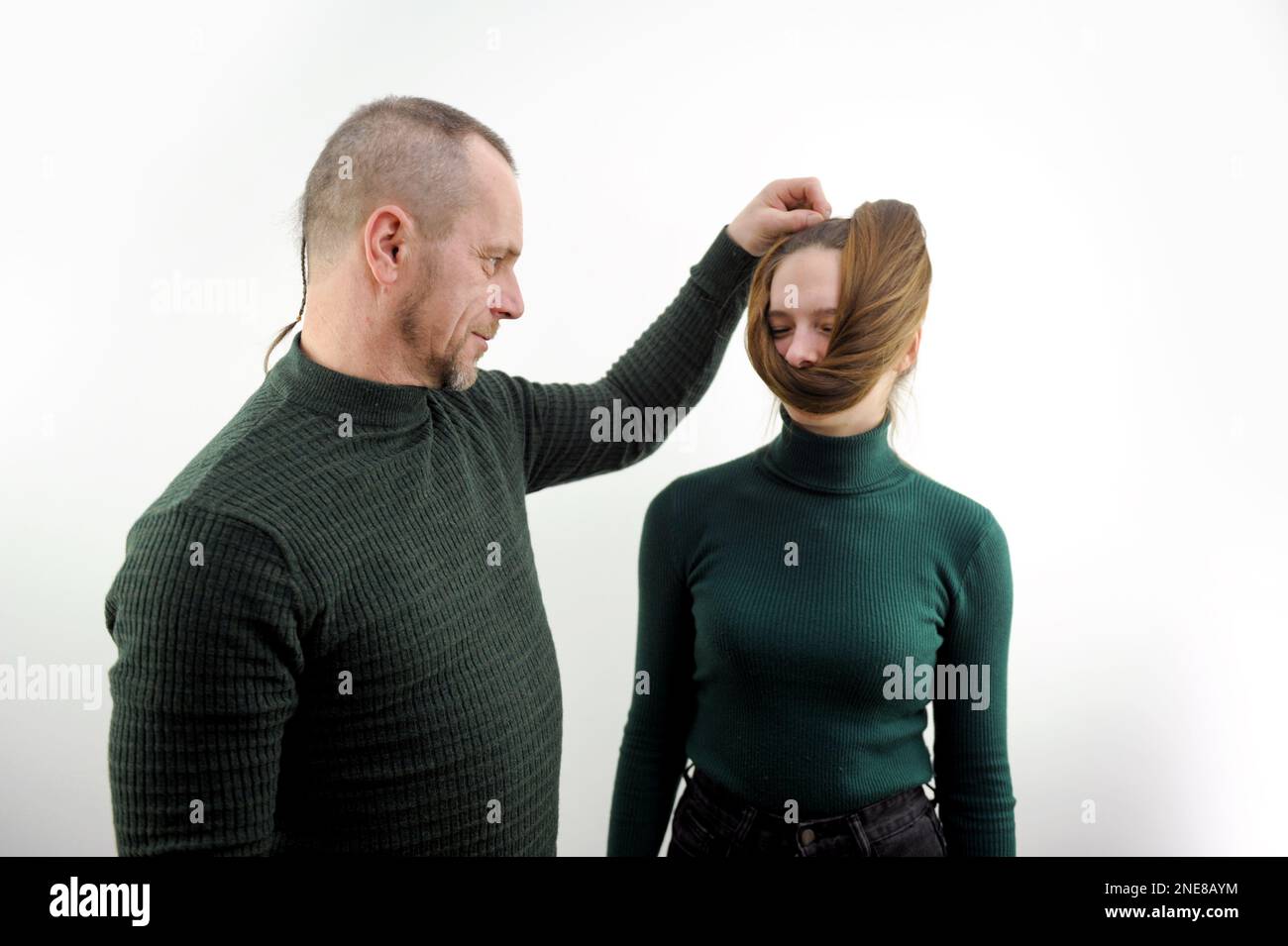 Photo de bande dessinée de l'homme enroulant les cheveux sur le visage de la fille mauvais comportement des enfants et des adultes relations dans la famille domineering père mari recherche de l'image Beauté exige le sacrifice sur le fond blanc conception Banque D'Images