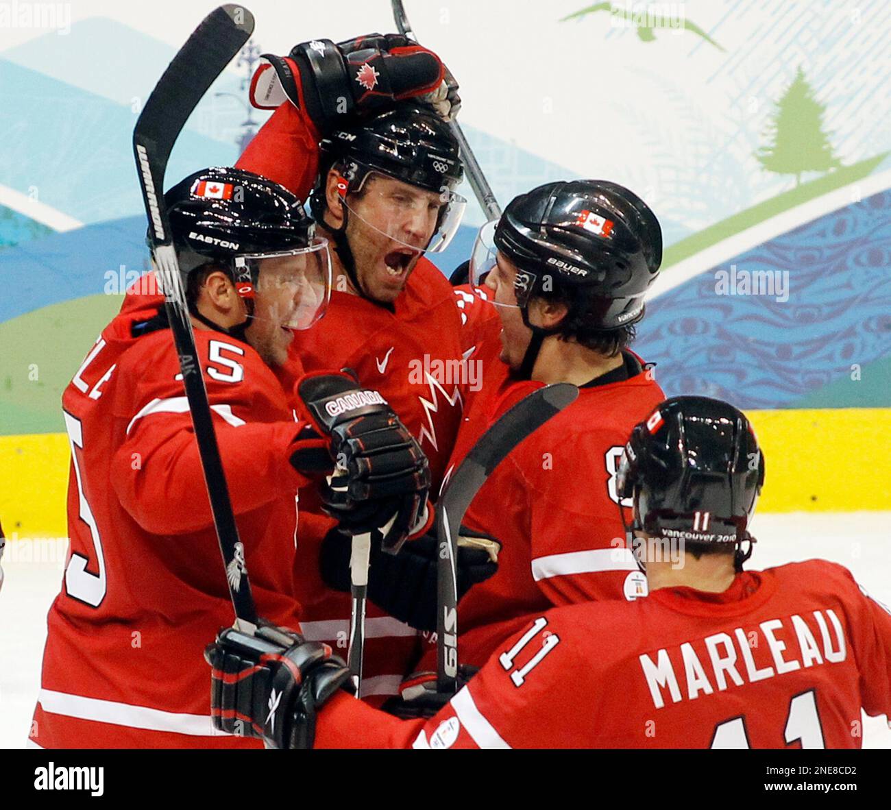 Canada's Joe Thornton, center, celebrates with Dany Heatley, left, Drew Doughty and Patrick Marleau after scoring the first goal against Germany during first period mens ice hockey action Tuesday, Feb. 23, 2010 at the 2010 Winter Olympic Games in Vancouver.(AP Photo/Ryan Remiorz, CP) Banque D'Images