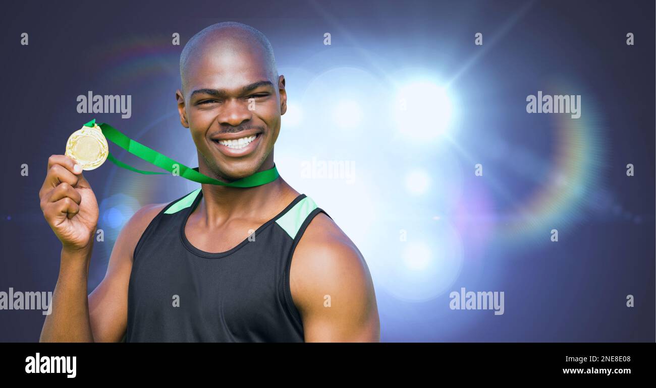 Portrait de l'homme afro-américain tenant la médaille autour de son cou contre des taches lumineuses brillantes Banque D'Images