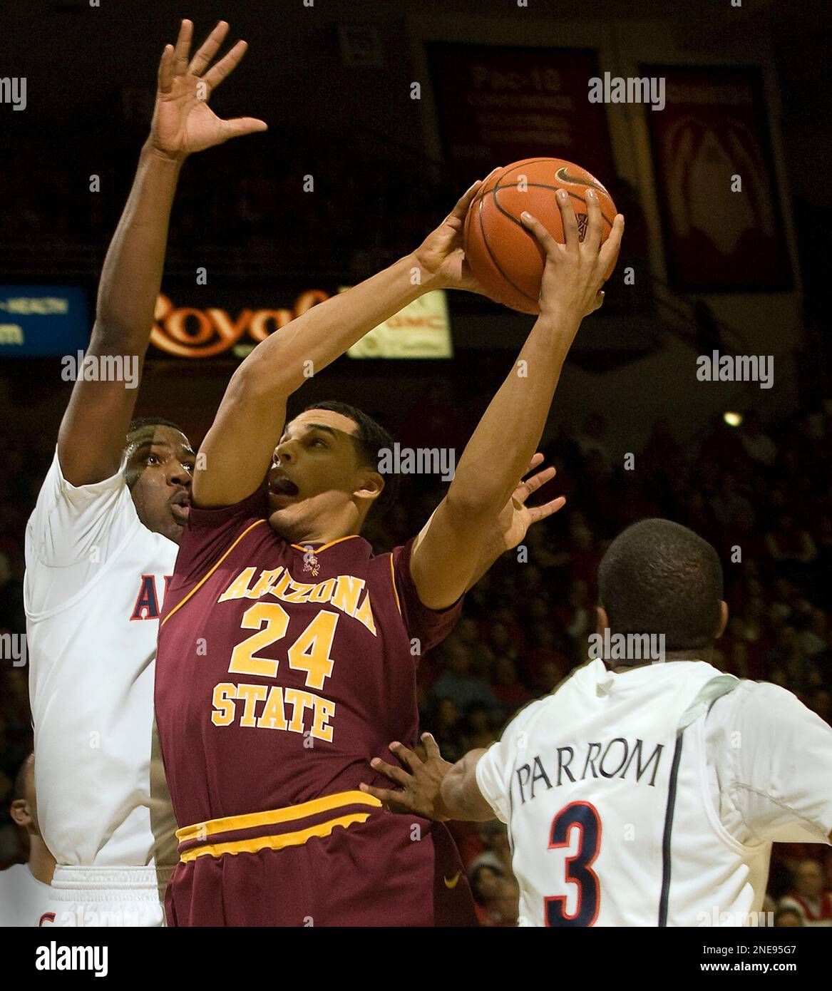 Arizona State's Trent Lockett (24) shoots over the defense of Arizona's Solomon Hill, left, and Kevin Parrom (3) in the first half of an NCAA college basketball game at McKale Center in Tucson, Ariz., Sunday, Feb. 21, 2010. (AP Photo/Wily Low) Banque D'Images