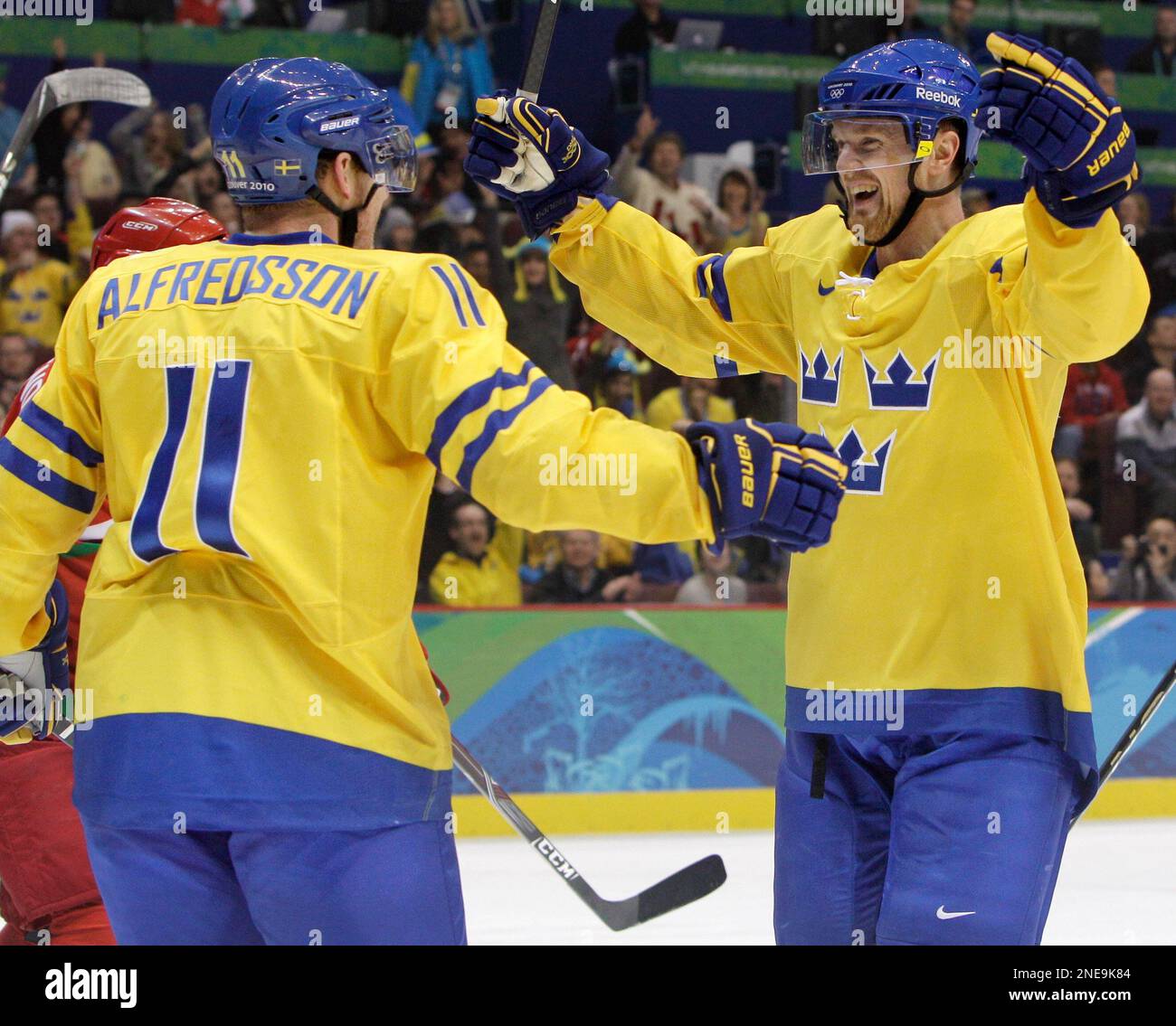 Sweden forward Daniel Alfredsson (11) celebrates with Henrik Sedin, right, after Alfredsson scored against Belarus late in the third period to seal a 4-2 win for Sweden in a preliminary round men's ice hockey game at the Vancouver 2010 Olympics in Vancouver, British Columbia, Friday, Feb. 19, 2010. (AP Photo/Matt Slocum) Banque D'Images