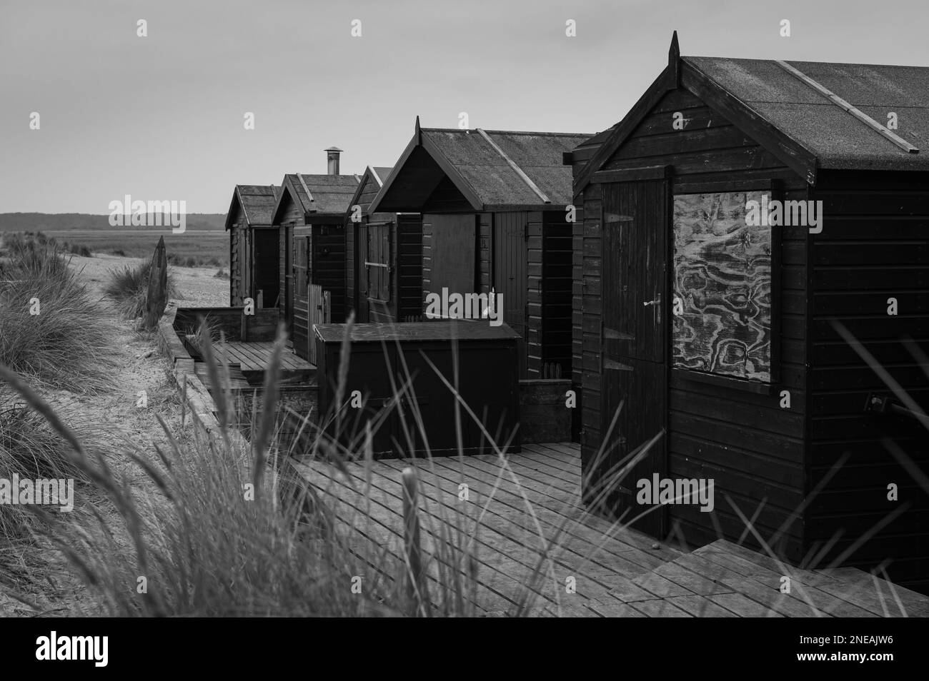 Cabanes de plage noires à Walberswick, Suffolk. Gris, moody. Banque D'Images