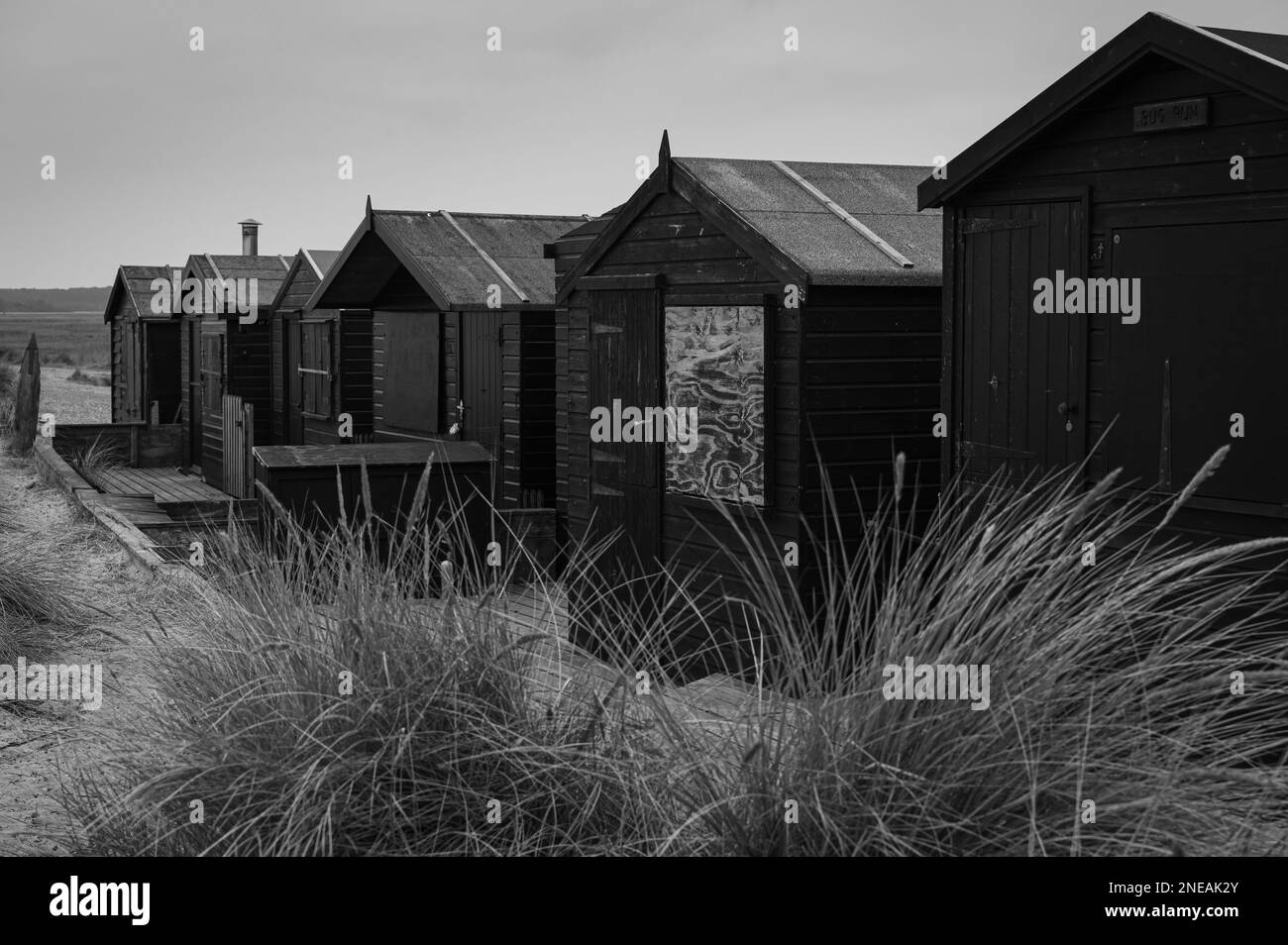 Cabanes de plage noires à Walberswick, Suffolk. Gris, moody. Banque D'Images