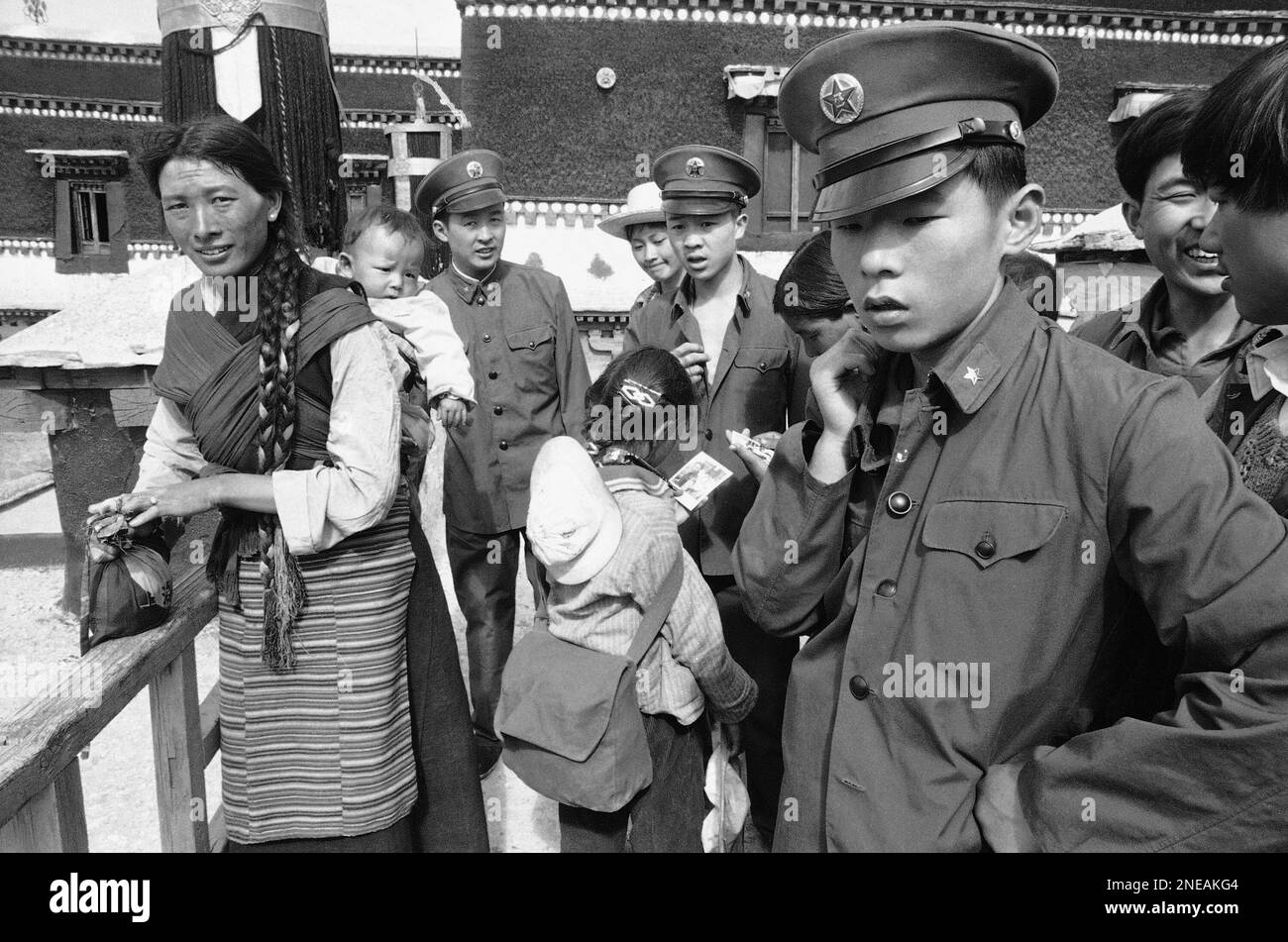 A Tibetan woman and Chinese soldiers of the People's Liberation Army pause on the roof of the Potala, once palace of Tibet's Dalai Lamas on July 16, 1985. During the 1966-76 Cultural Revolution Chinese troops and Red Guards took part in suppressing Tibet's Buddhist religion and destroying many sanctuaries. (AP Photo/Neal Ulevich) Banque D'Images