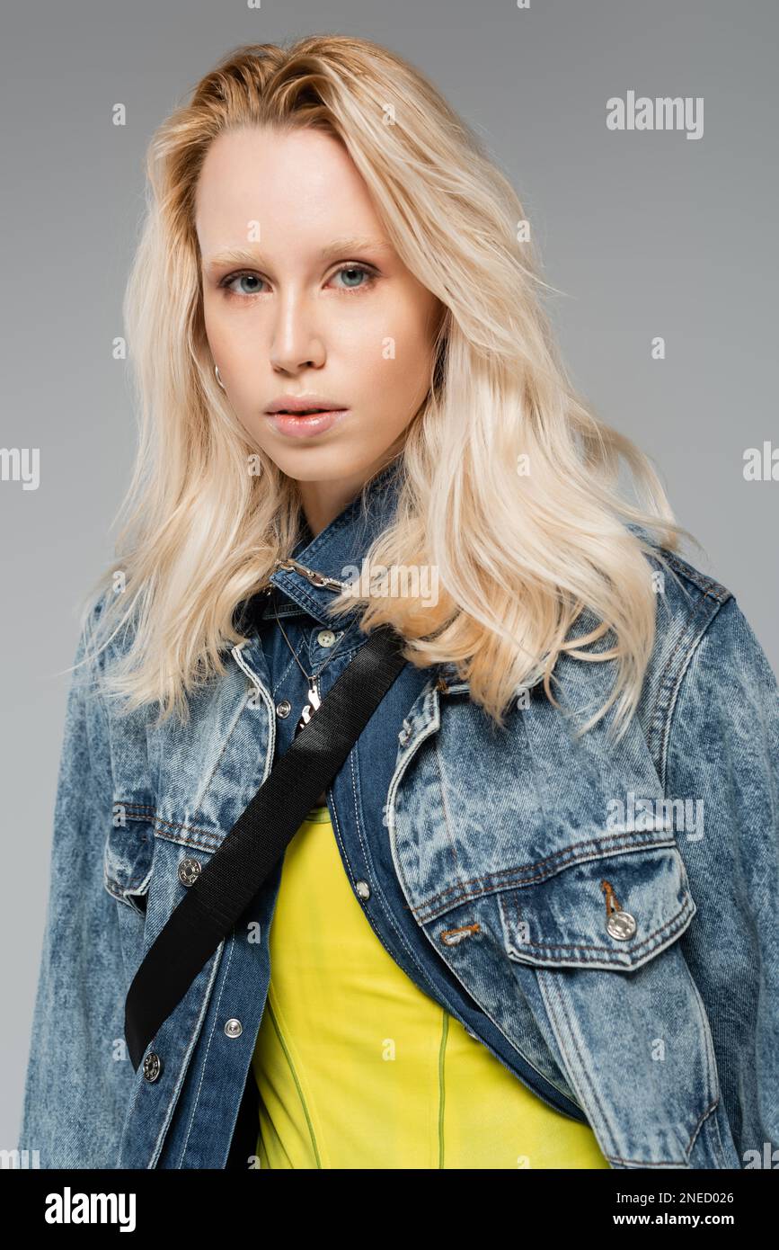 jeune modèle blond avec des yeux bleus regardant la caméra isolée sur gris, image de stock Banque D'Images