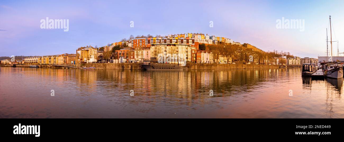 Vue panoramique sur le bar-restaurant flottant grain Barge avec des rangées de maisons colorées derrière, vue depuis la marina, au lever du soleil. ROYAUME-UNI Banque D'Images