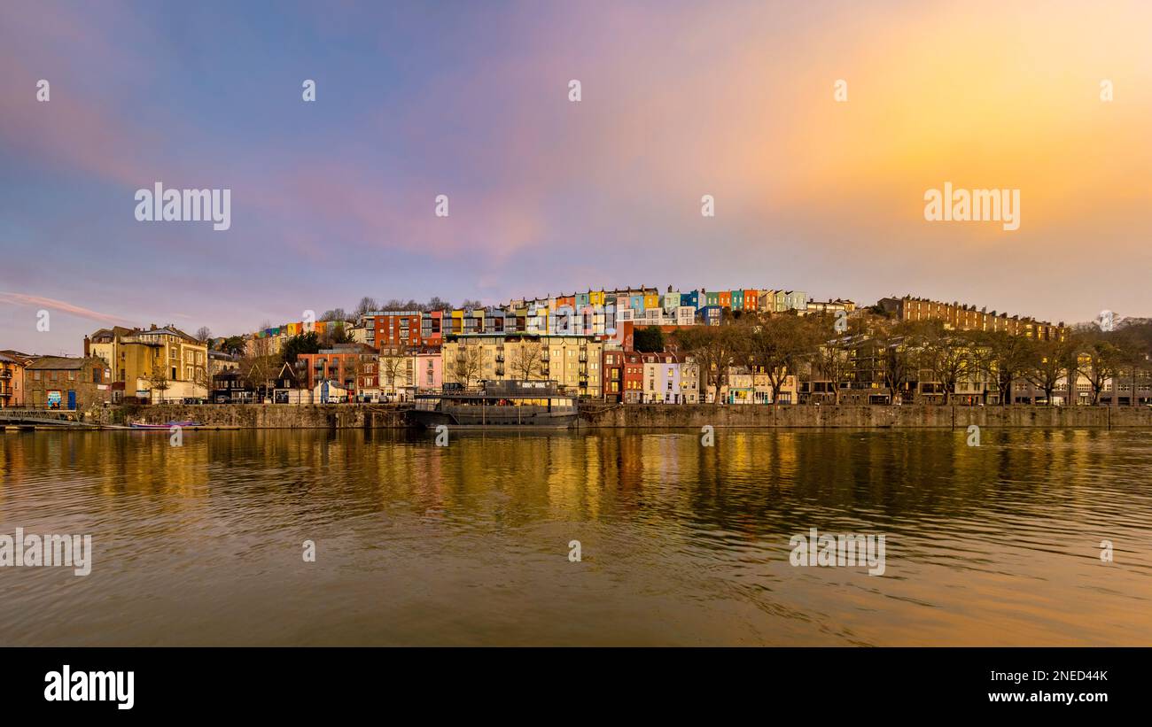 Vue panoramique de la grange des grains amarrée sur la rivière Avon avec des rangées de maisons colorées derrière, vue de la marina de Bristol au lever du soleil. Banque D'Images