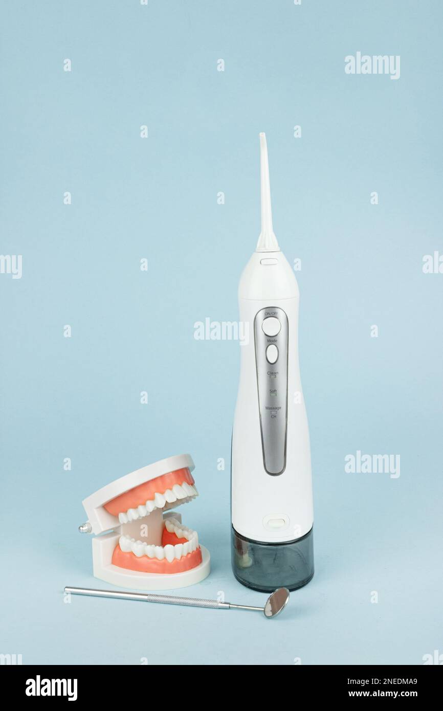Fausses dents avec un irrigateur à cavité buccale qui nettoie les dents et les mâchoires. Instruments de dentisterie et concept de contrôle de l'hygiéniste dentaire Banque D'Images