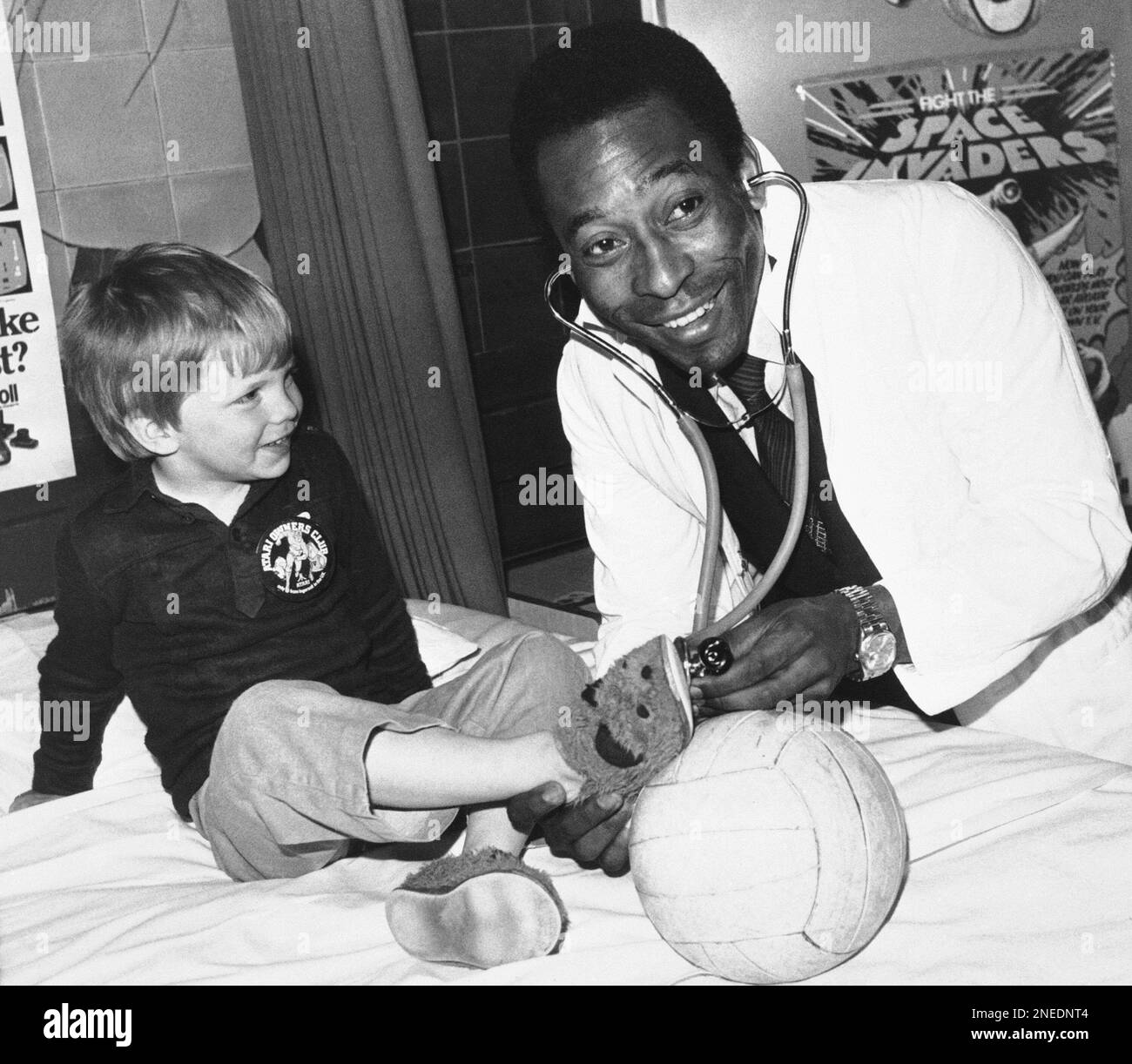 Great Brazilian football star Pele, 40 (real name Edson Arantes do Nascimento) plays doctor during visit to the Children?s Ward of the Middlesex Hospital in London on April 30, 1981 where his captivated ?patient? proved to be three year old James Scully of Hoddesdon, Herts. (AP Photo) Banque D'Images